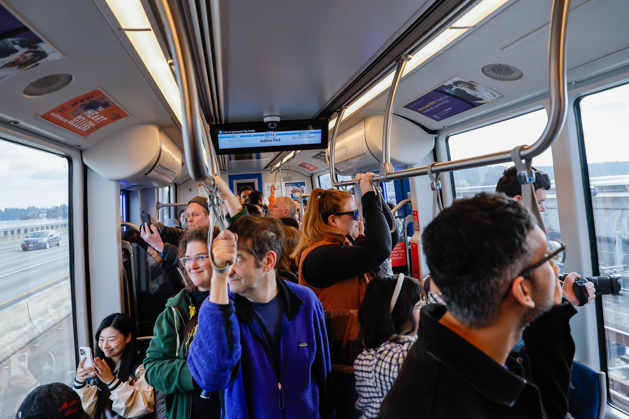 People look out the windows of a westbound light-rail train as it crosses the floating highway bridge on I-90 on Saturday. This is the world’s first passenger rail line to run across a floating bridge. (Jennifer Buchanan / The Seattle Times)