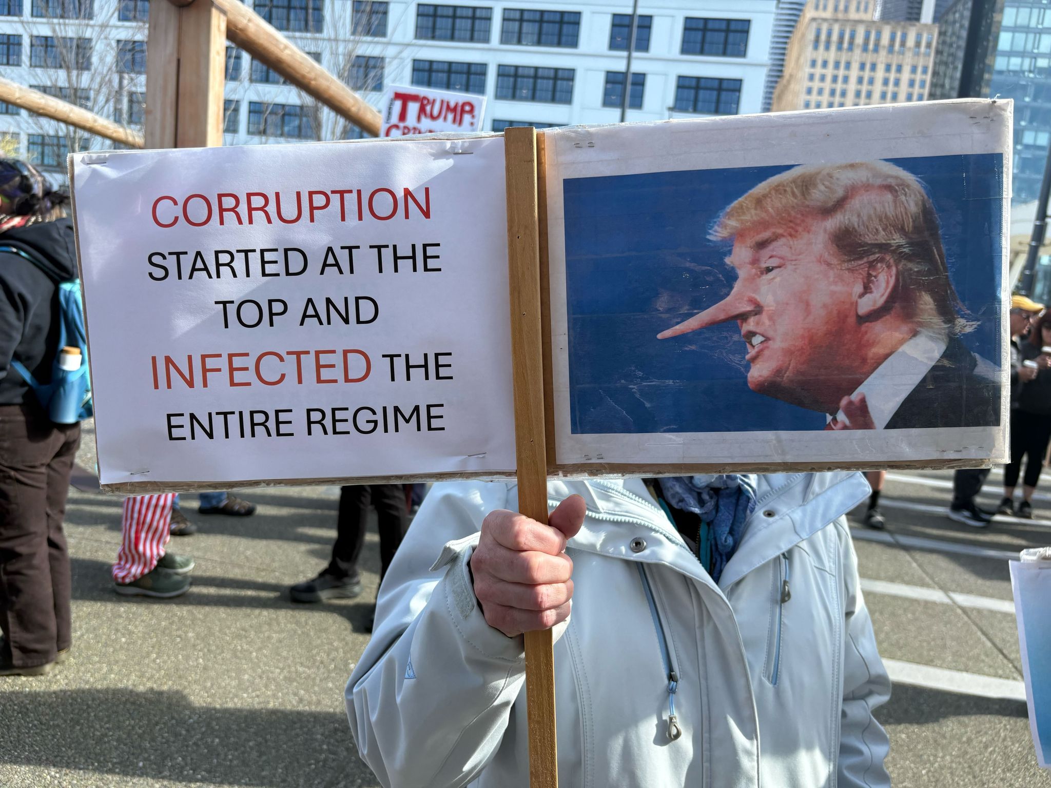 Susan Davidson with a protest sign at the No Kings waterfront action on Saturday. (Caitlyn Freeman / The Seattle Times)