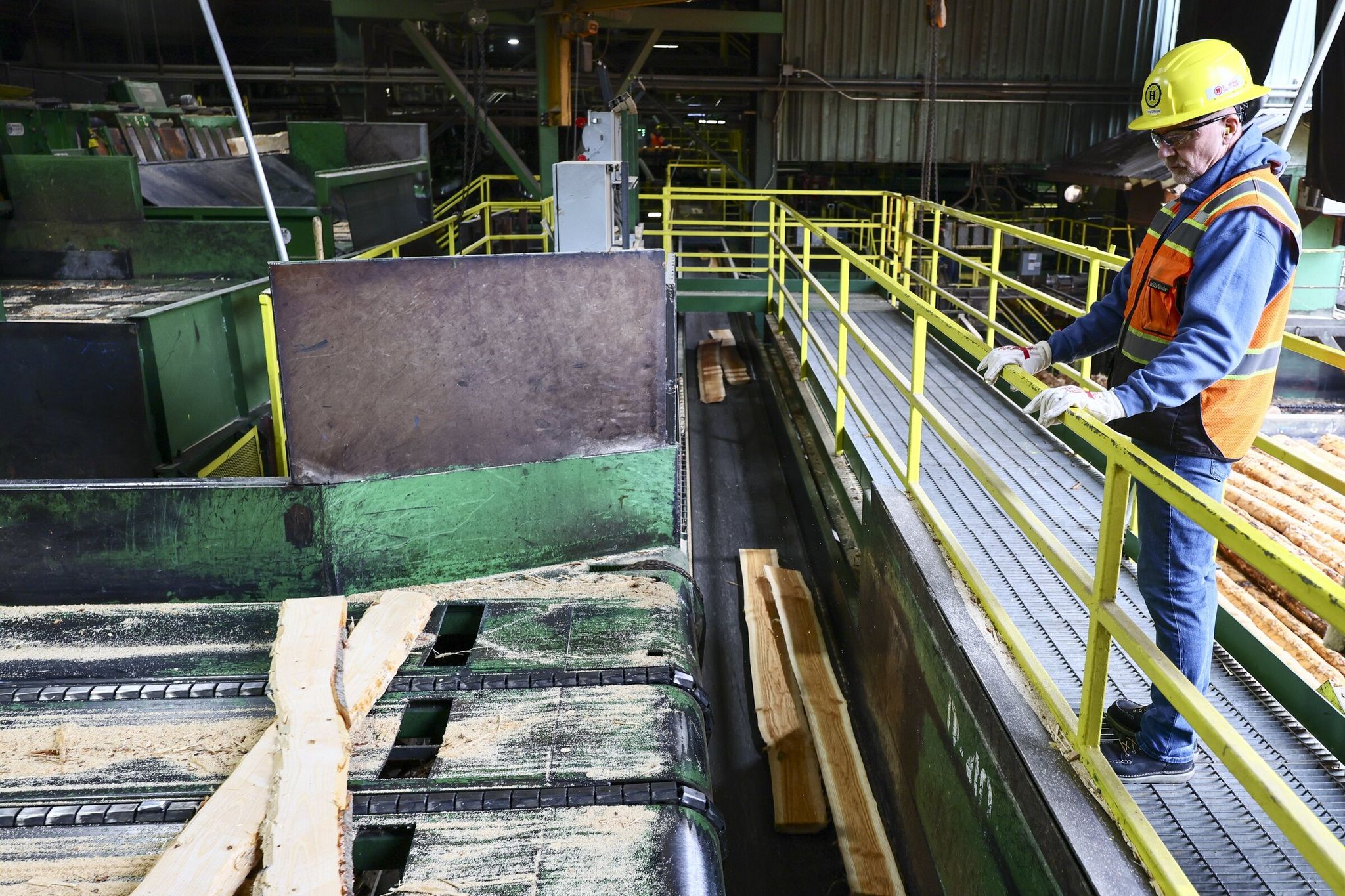 Tony Gillespie, the plant manager, inspects freshly cut boards at the Hampton Lumber sawmill in Morton, Lewis County, last month. “We use our logs and get everything we can out of them. We replant, and we grow the forest again,” Gillespie said. “We want this to continue for hundreds of years.” (Kevin Clark / The Seattle Times)