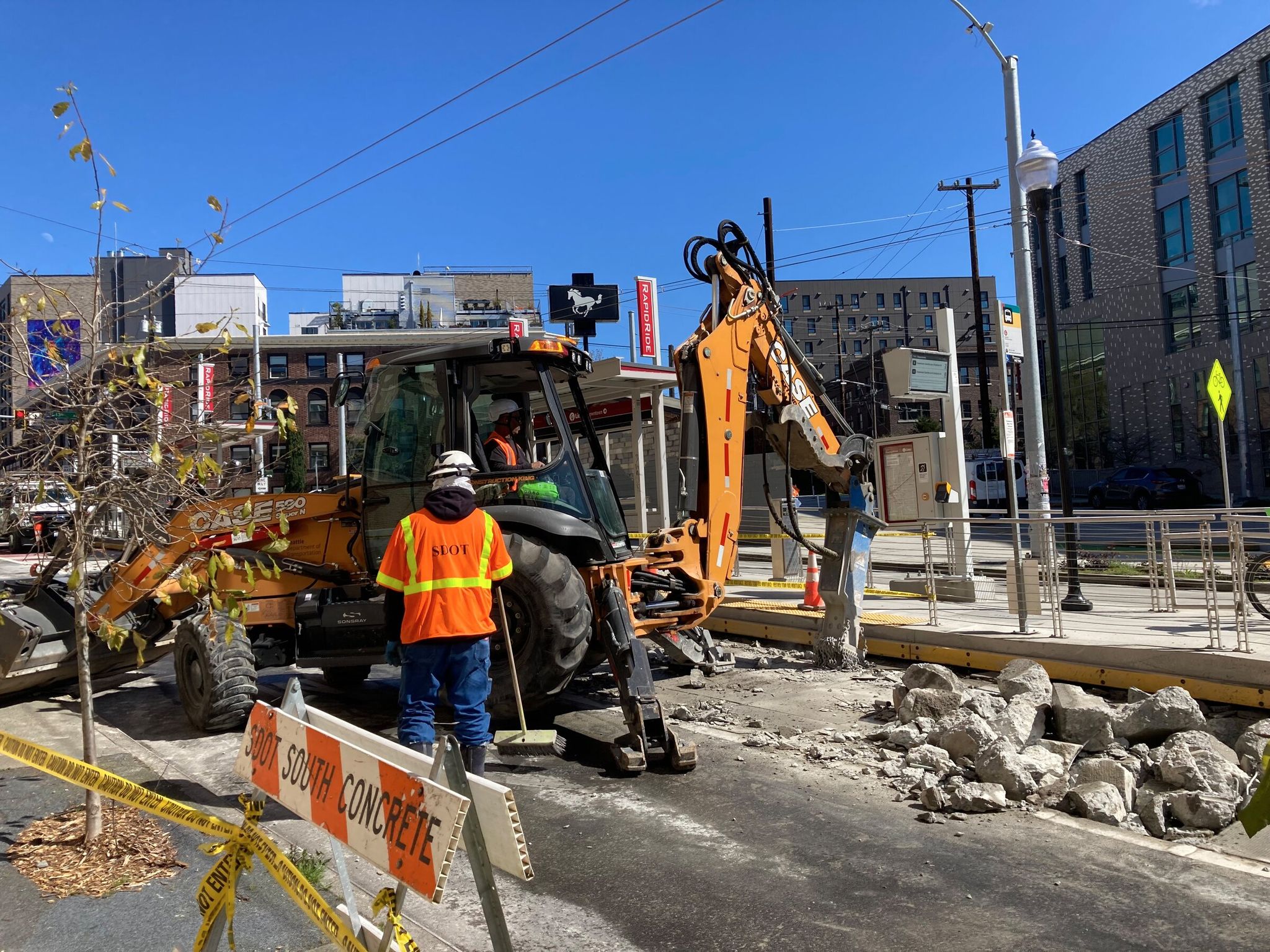Workers break up concrete on March 26 to provide a long-term fix for the issue that some RapidRide G platforms were built slightly too high. New pavement now replaces the steel plates that for more than a year slightly raised buses to improve access for people with limited mobility. (Photo courtesy of Don Glickstein)