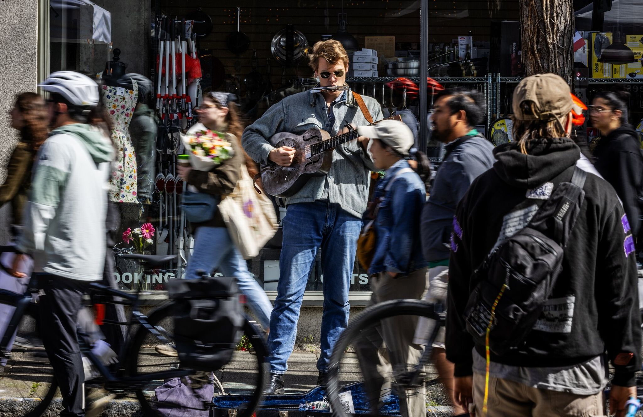 Musician Conrad Brody in sunglasses — he even performed several old songs about the sun on Sunday at the Ballard Farmers Market in Seattle. (Ken Lambert / The Seattle Times)