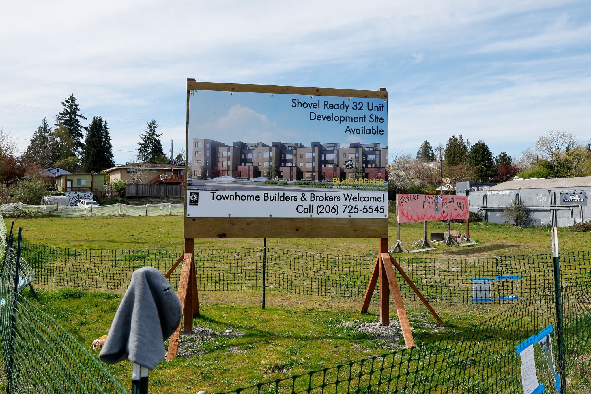 Signs advertising the lot ready for development and the future home of Dragon Land were visible Monday on the vacant lot next to Third Place Books in South Seattle. (Jennifer Buchanan / The Seattle Times)