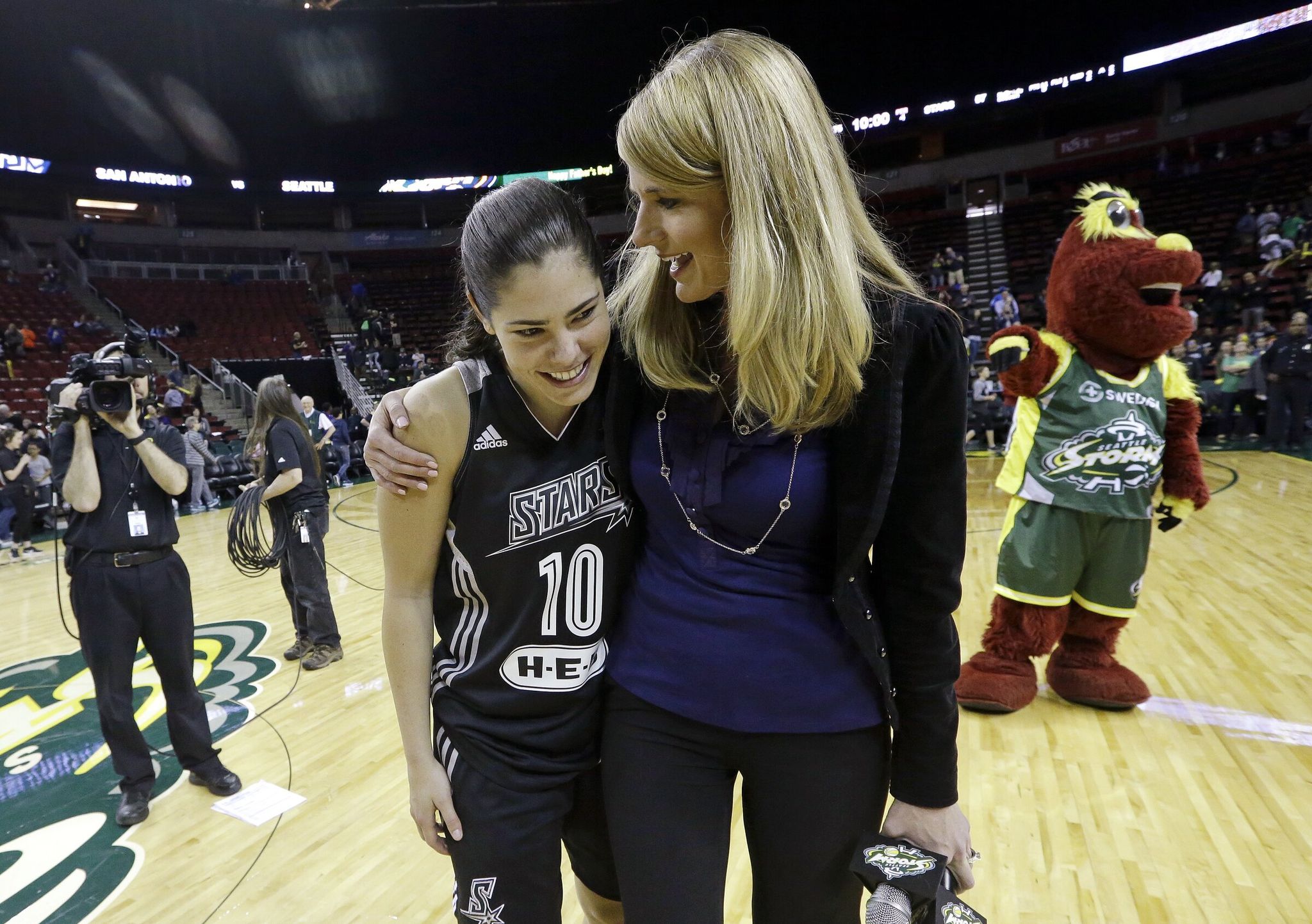 Kelsey Plum (10) hugs Storm broadcaster Elise Woodward after she interviewed her on the court following a 2017 game. (Elaine Thompson / AP)