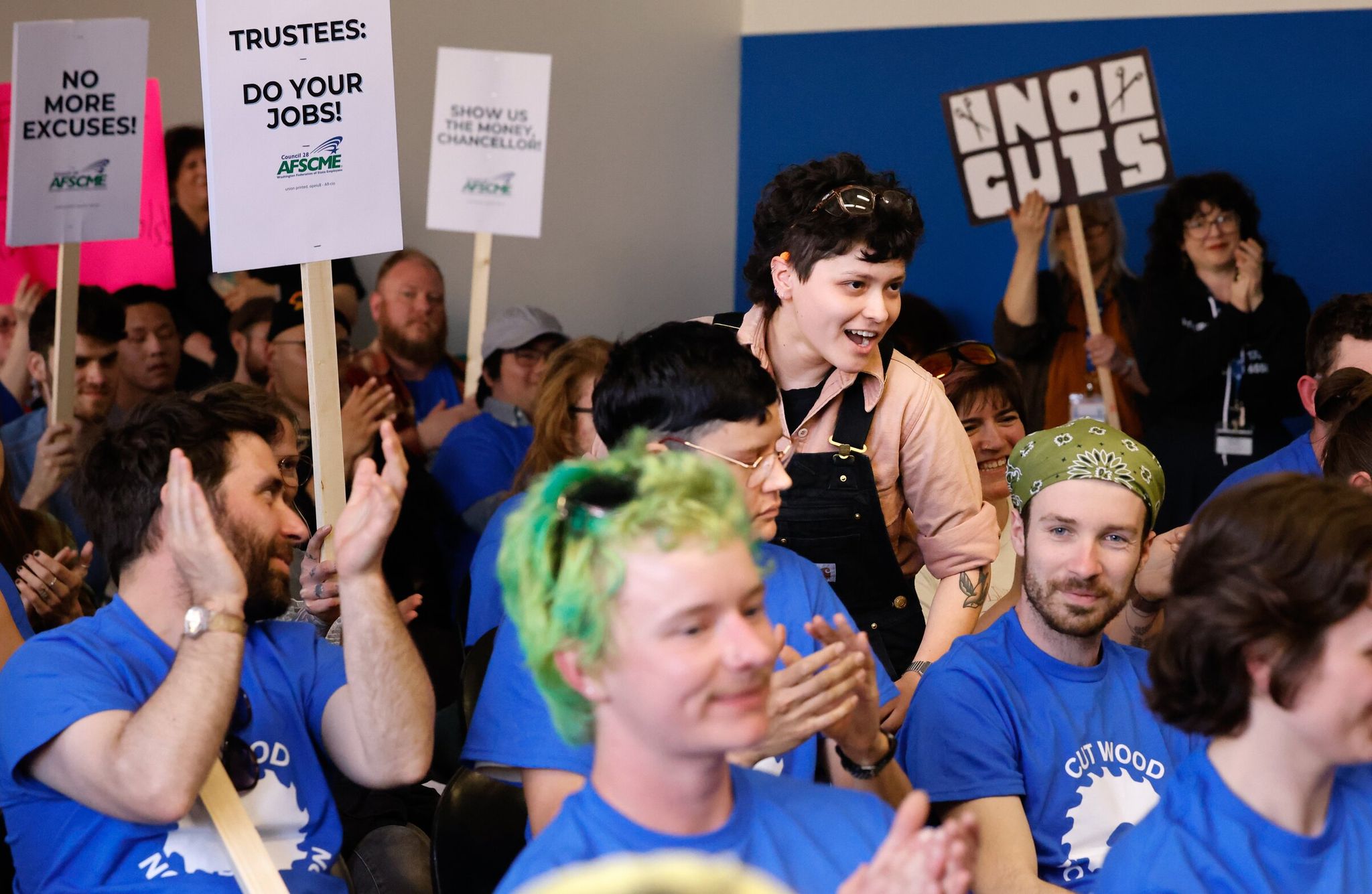 Lizbeth Chaydes, standing, receives applause after speaking at the Seattle Colleges board of trustees meeting. Chaydes, a carpentry student and president of the Wood Technology Center student government, expressed concern about the potential sale of the purpose‑built Wood Technology Center building in the Central District. (Karen Ducey / The Seattle Times)