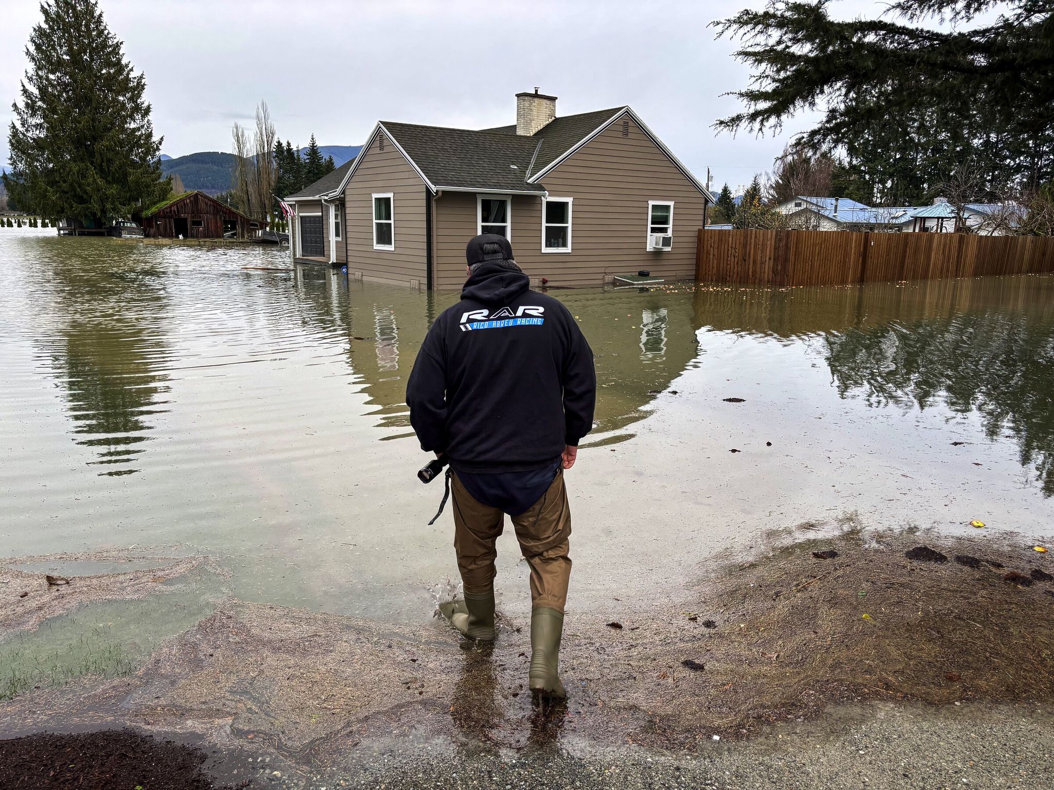 A man inspects his flooded home in Sedro-Woolley on Dec. 11, 2025. (Jessica Fu / The Seattle Times)