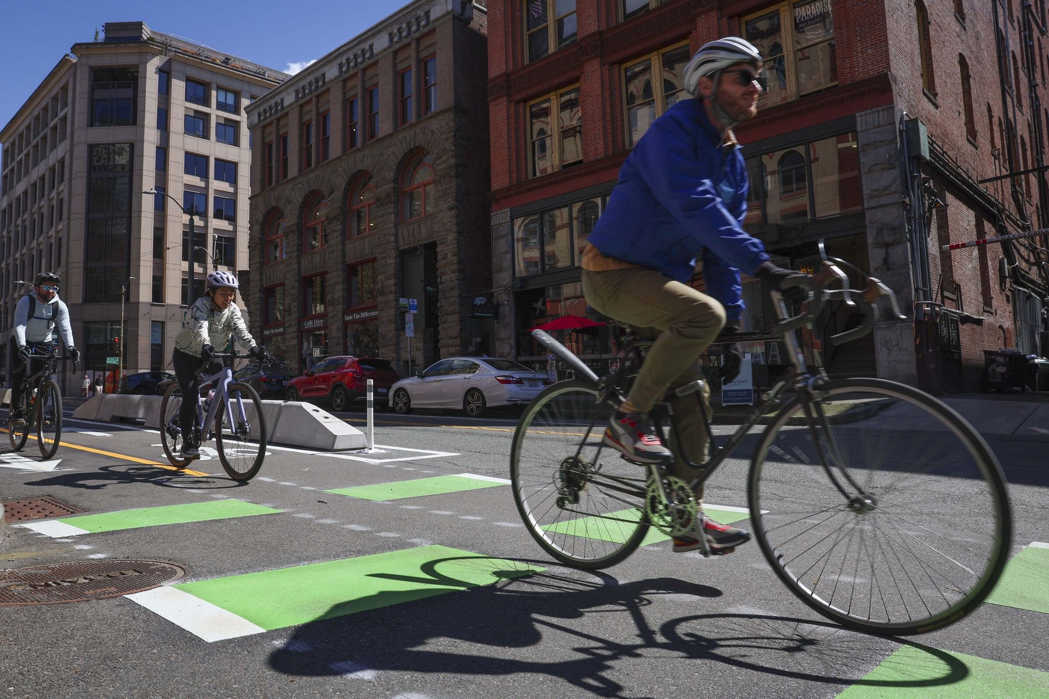 Cyclists ride the new bikeway on Yesler Way this week — a key link in the city network. (Ivy Ceballo / The Seattle Times)