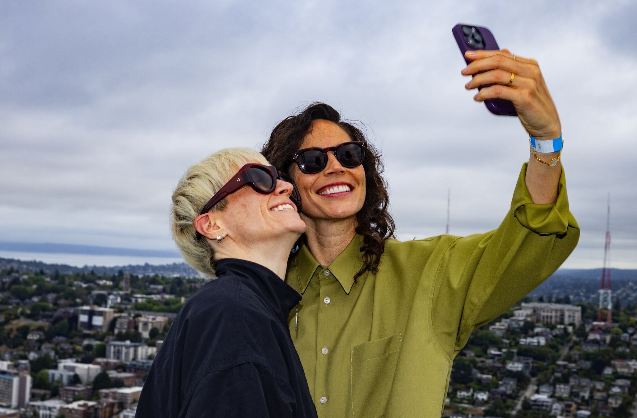 Megan Rapinoe smiles as Sue Bird takes a selfie atop the Space Needle before Bird raised a 'Forever Sue' flag, Aug. 17, 2025, in Seattle, ahead of the unveiling of Bird's statue. (Ken Lambert / The Seattle Times)