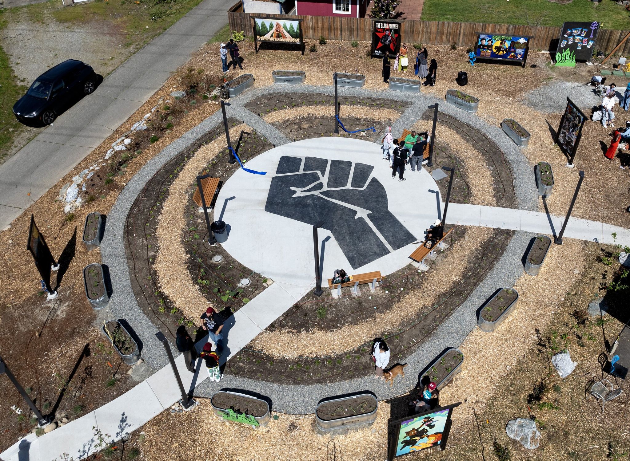 Plants and flower beds surround a concrete slab with a Black Power fist in the new park. (Nick Wagner / The Seattle Times)