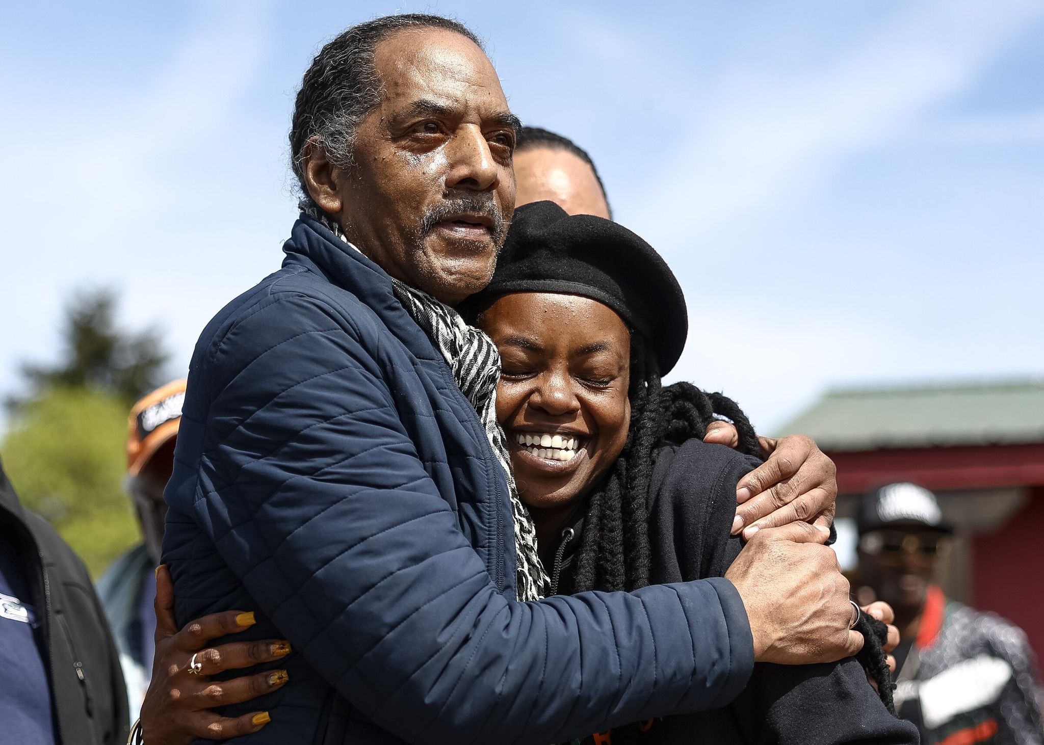 Aaron Dixon, one of the co-founders of the Seattle chapter of the Black Panther Party, embraces Nyema Clark, founder and executive director of Nurturing Roots, after the opening of Black Panther Park on Sunday in Skyway. (Nick Wagner / The Seattle Times)