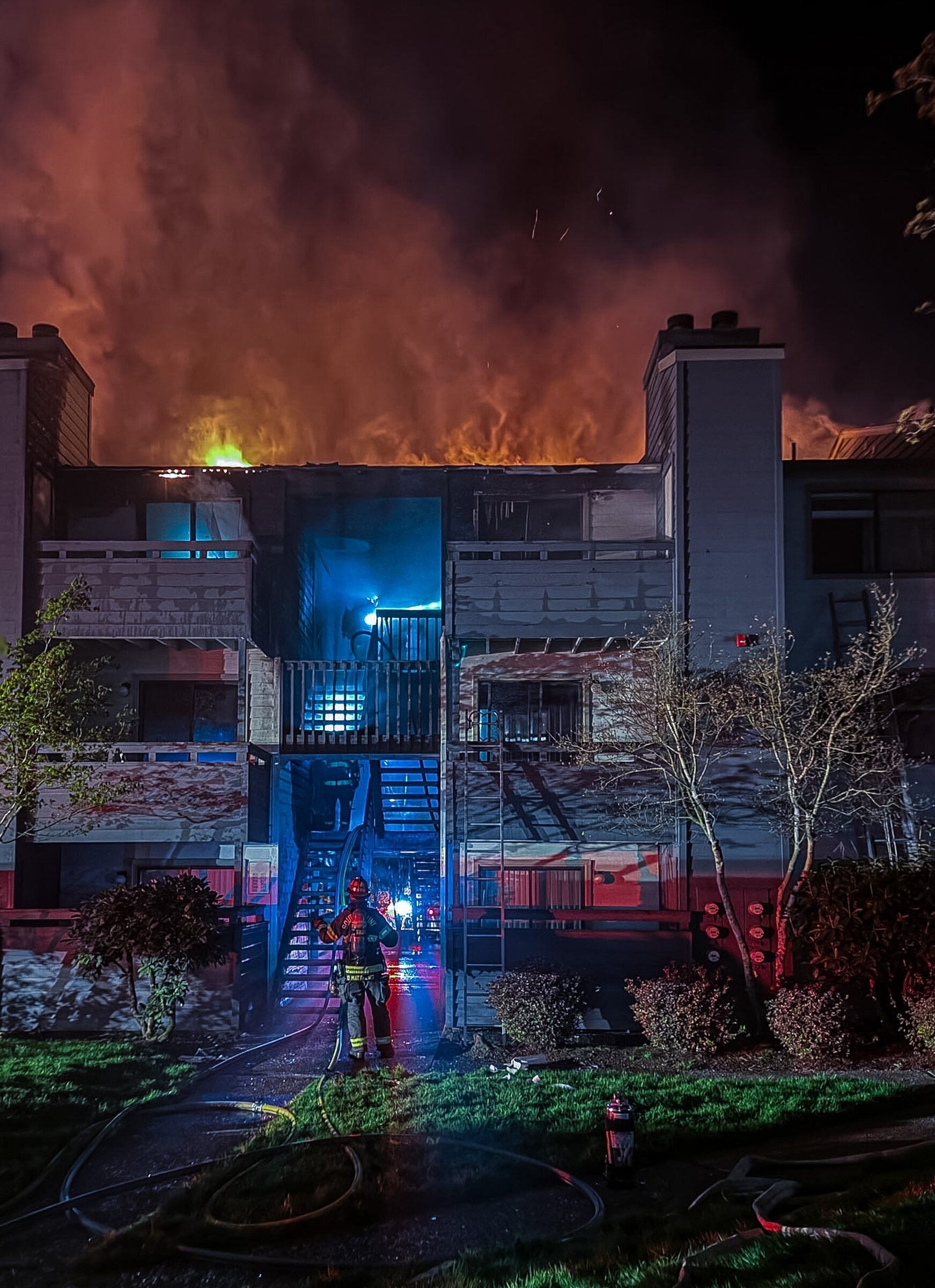 South County Fire firefighters rescued two people and a dog from a third-floor apartment window as flames engulfed a Mountlake Terrace building early Sunday morning. (Courtesy South County Fire)
