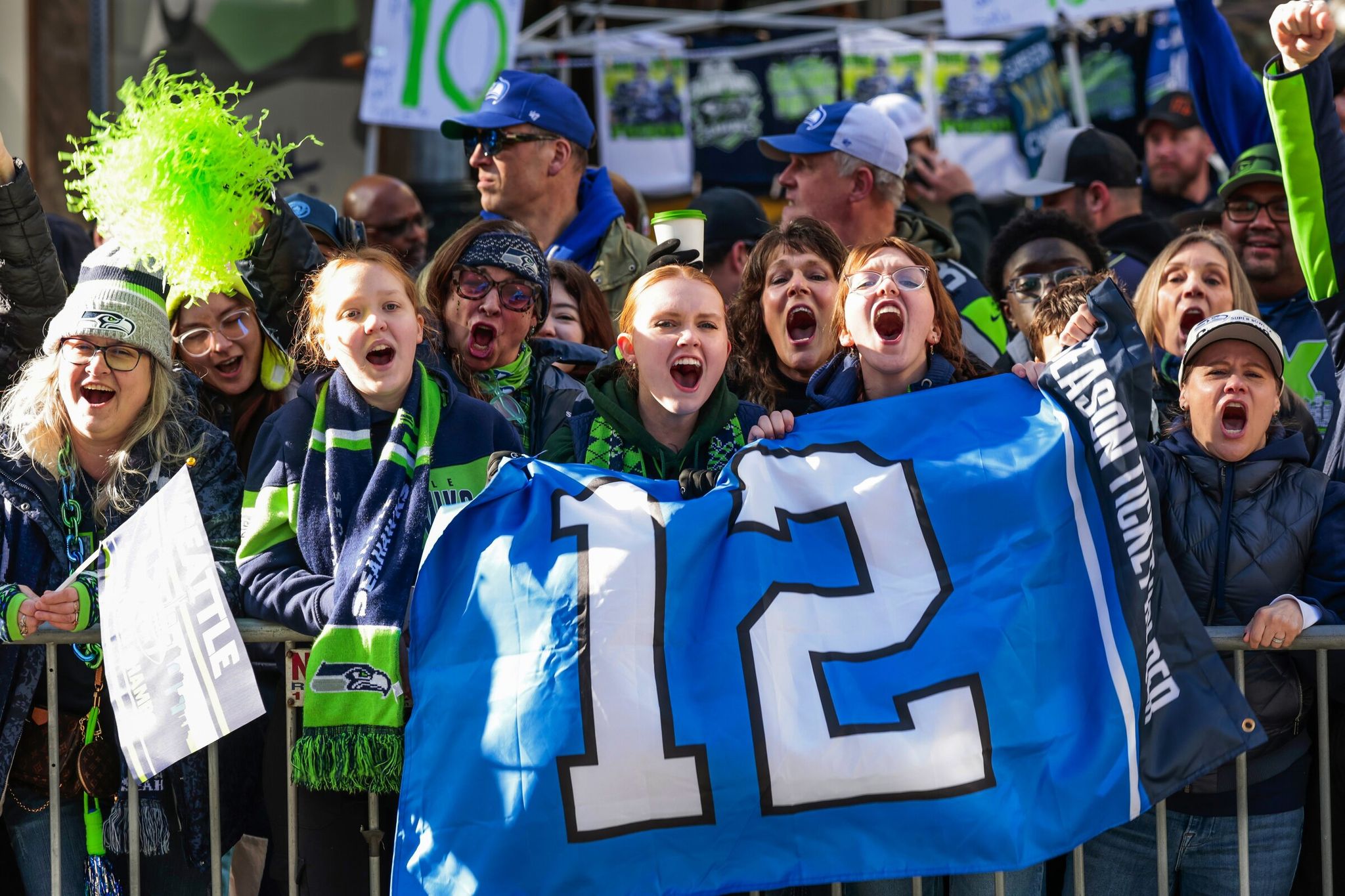 The Jakobsen sisters from Everett — left to right: Ashley, 13; Kailee, 17; and Emma, 15 — line up along Fourth Avenue awaiting the Seahawks world champions parade in Seattle on Feb. 11. (Karen Ducey / The Seattle Times)