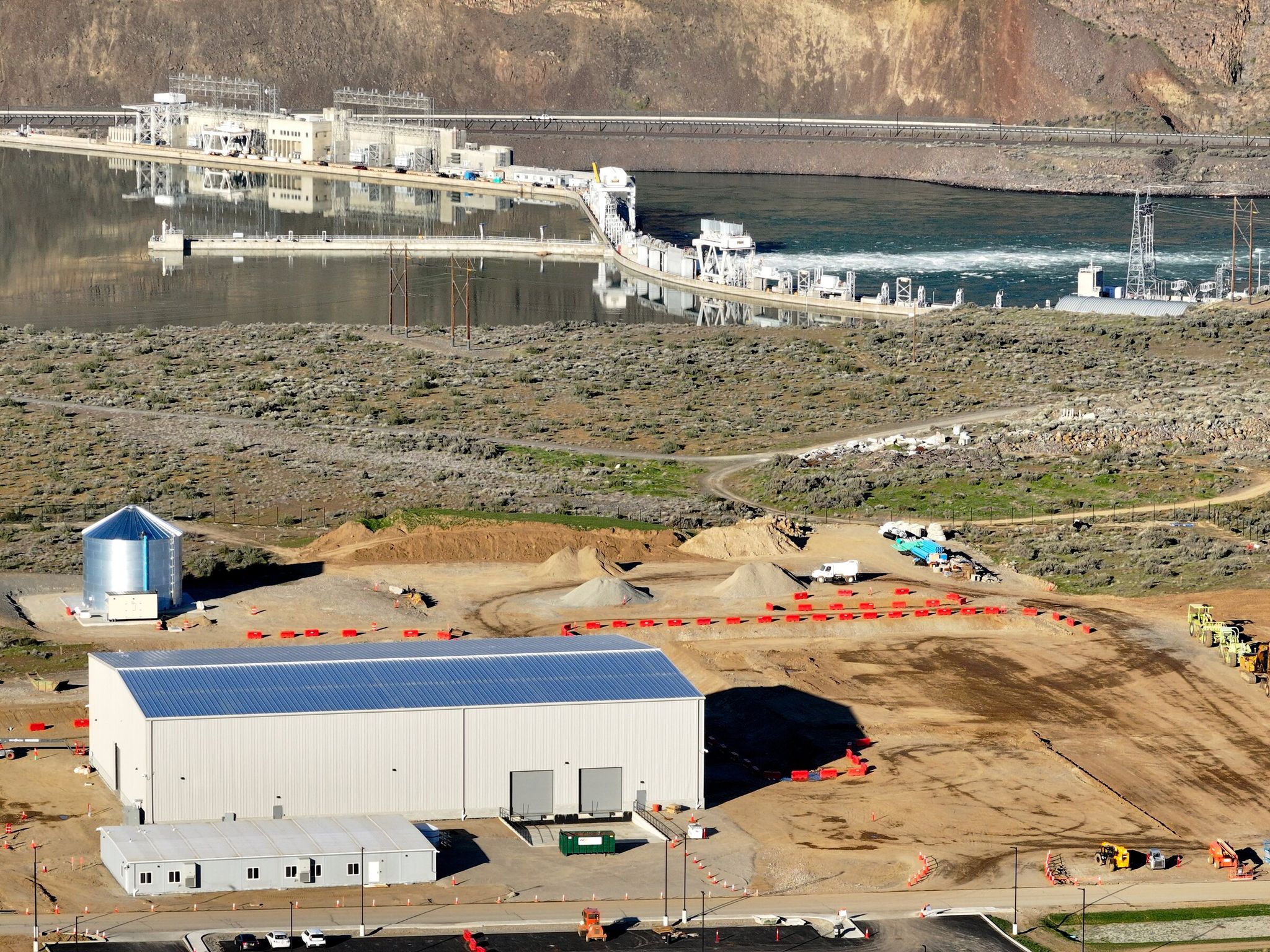 In the foreground is the assembly building and office of Helion's fusion power plant; in the background is the Columbia River and the Rock Island Dam in Chelan County. (Karen Ducey / The Seattle Times)