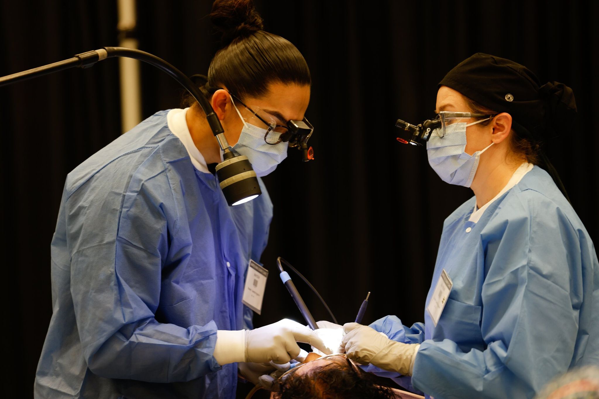 Lisa Fidler (right) and Mason Marchant (left), dental hygienists, clean Lilia Garcia's teeth at the Seattle/King County clinic. (Karen Ducey / The Seattle Times)