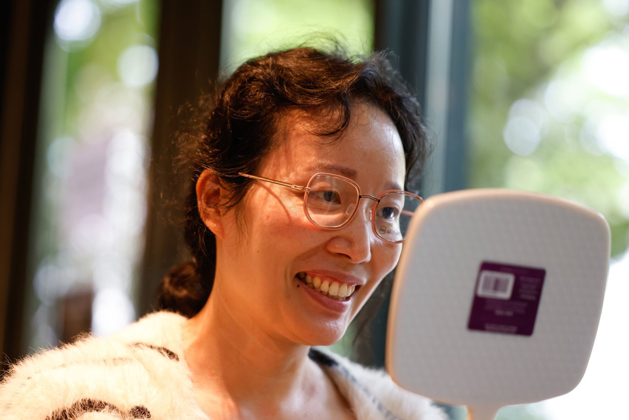 Rachel Fan tries on a pair of eyeglass frames. (Karen Ducey / The Seattle Times)