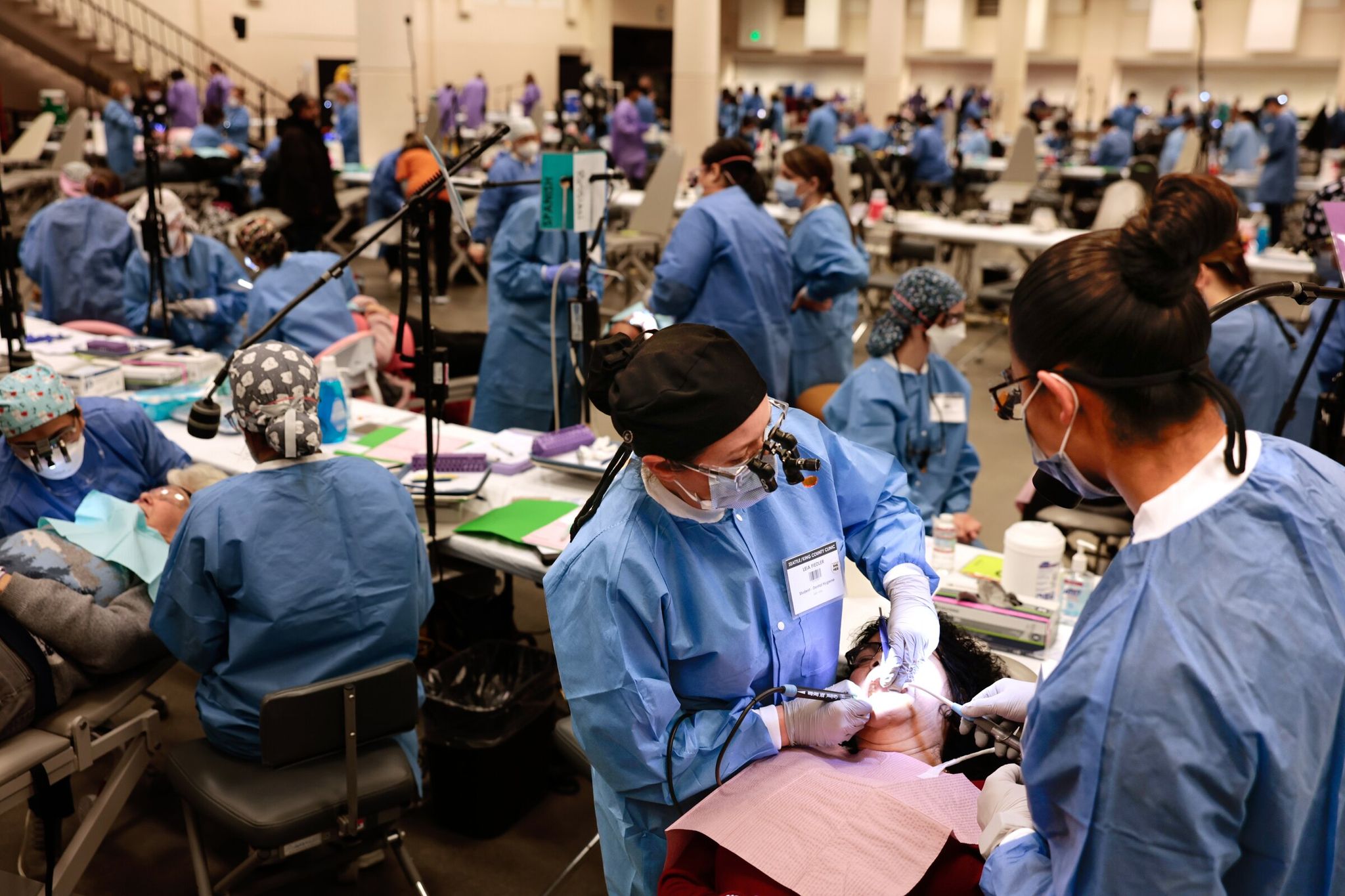 Lisa Fiedler, left, and Mayson Marchant, right, dental hygienists, give Lilia Garcia, center, a teeth cleaning at the Seattle/King County Clinic in Seattle on Thursday, April 23, 2026. (Karen Ducey / The Seattle Times)