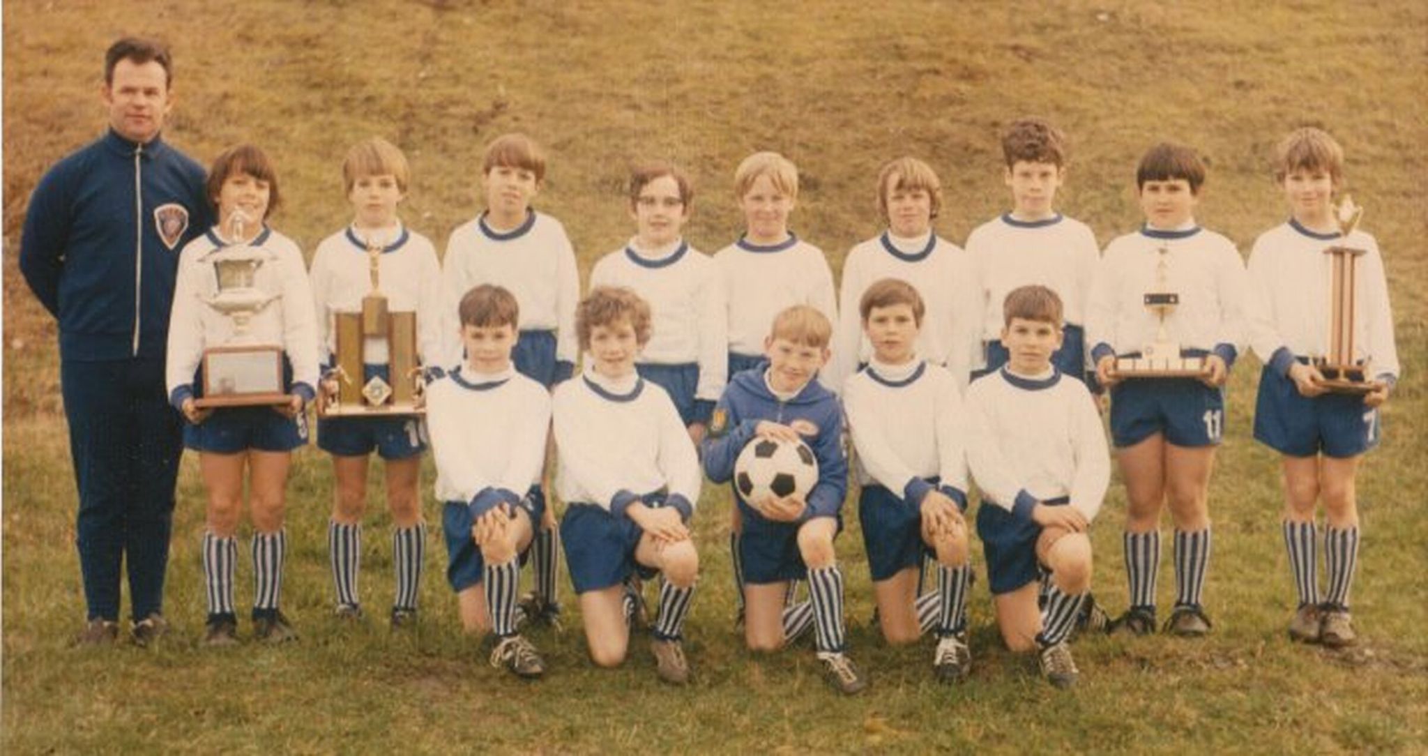 The 1974 Lake City Hawks team poses for a team photo with their trophies. Brian Schmetzer is in the back row, far right. Fred Hamel is in the back row, fourth boy from the left, wearing glasses. Walt Schmetzer, Brian’s father, is the coach. (Photo courtesy of Fred Hamel)