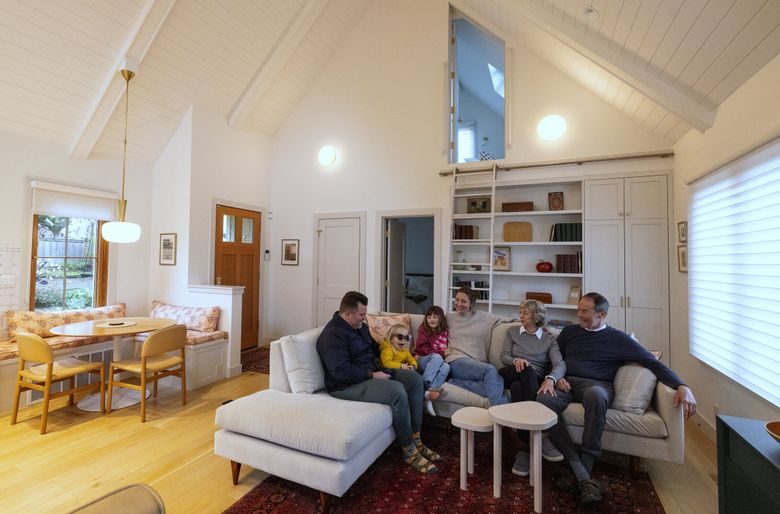 From left, Logan Cox, with son Jude, 2, daughter Simone, 6, and wife Sara Knowles, visit Sara’s parents Susan and Tony Knowles, at right, inside the DADU behind Logan and Sara’s house, March 29, in Seattle’s Beacon Hill neighborhood. (Ken Lambert / The Seattle Times)