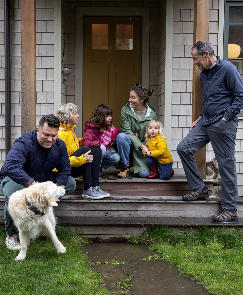 From left, Logan Cox and the family dog Homer, Susan Knowles, Sara Knowles with kids Simone and Jude, and Tony Knowles, spend time on the stoop of the DADU behind Logan and Sara’s home. (Ken Lambert / The Seattle Times