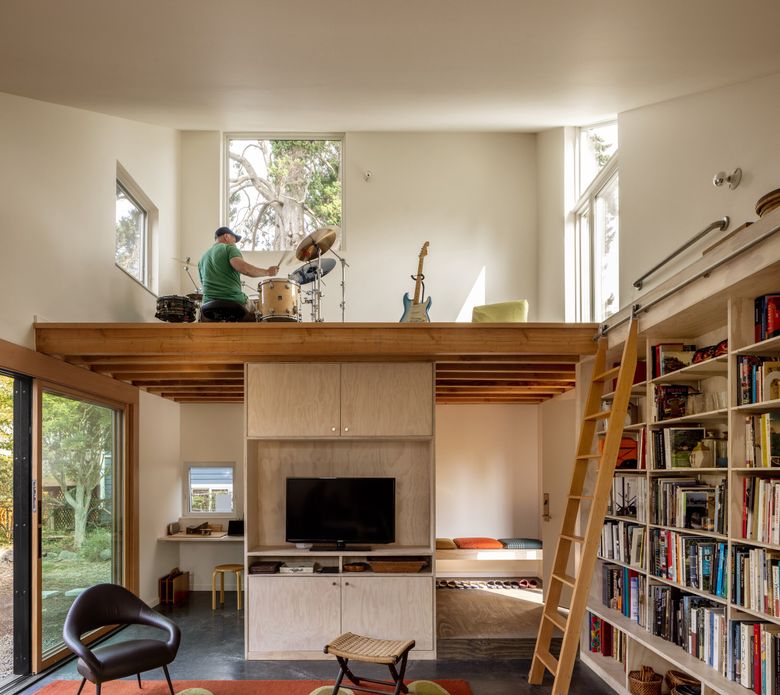 In Ken Tadashi Oshima’s North Seattle DADU, his partner, Brian Ormiston, plays drums in the multipurpose loft.  (Rafael Soldi / Courtesy of Robert Hutchison Architecture)