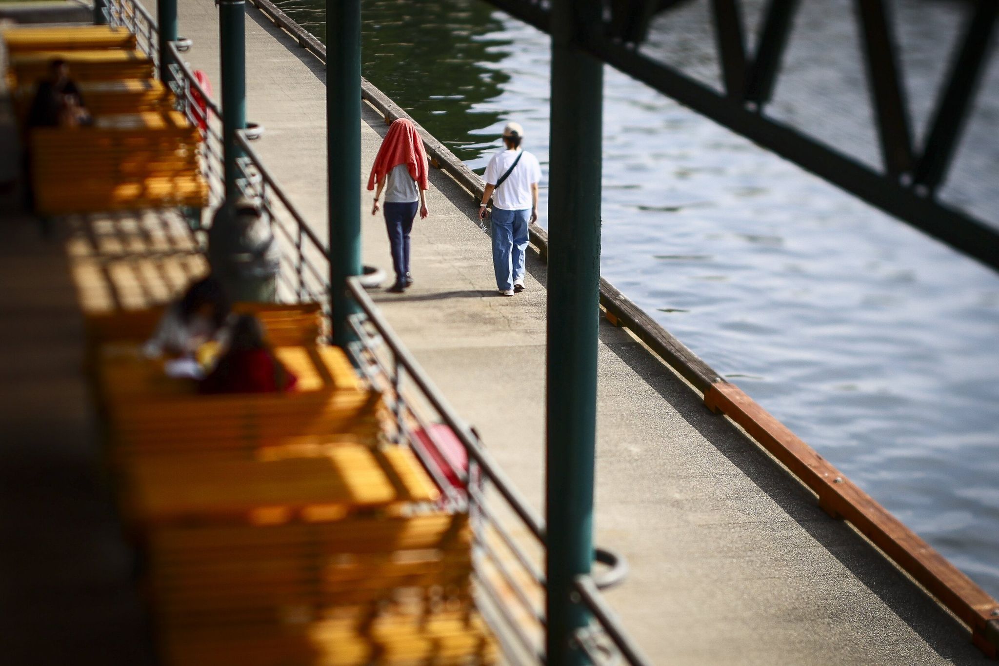 Pedestrians walk the boardwalk Friday afternoon at Gene Coulon Memorial Beach Park in Renton. (Kevin Clark / The Seattle Times)