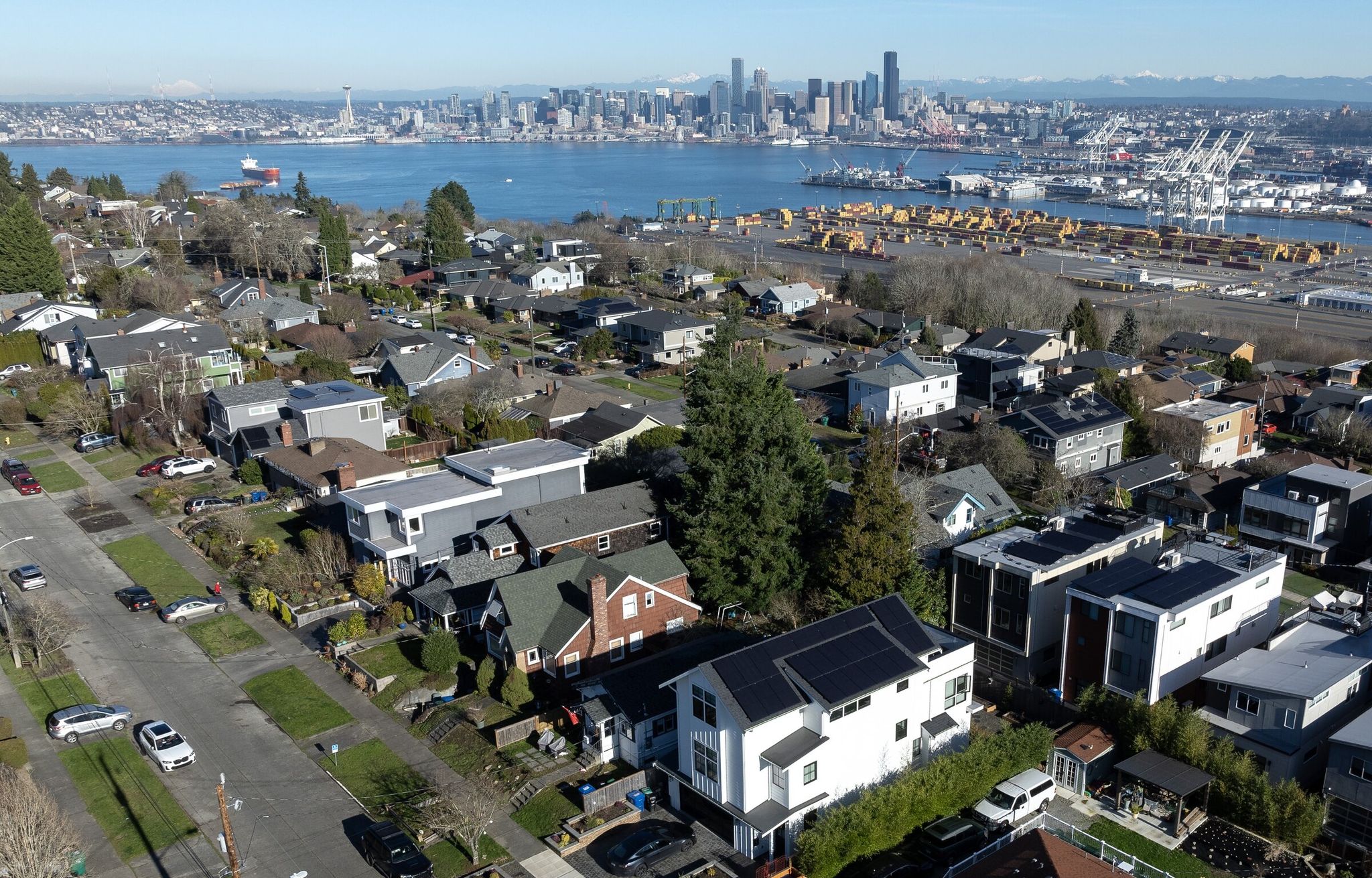 The downtown Seattle skyline is seen behind rows of houses in West Seattle. (Nick Wagner / The Seattle Times)