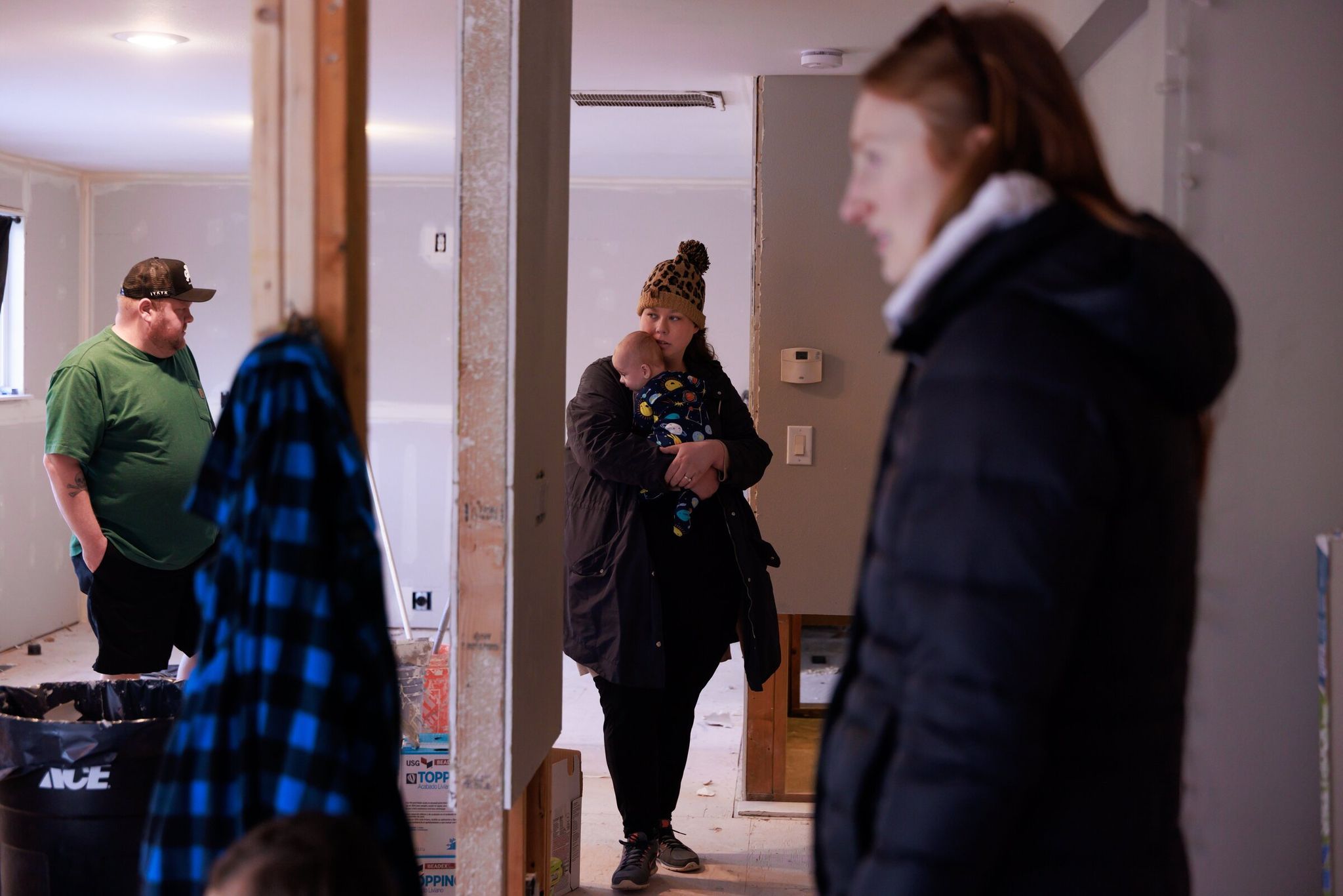 Kevin Week and Jessica Adams (holding baby Jackson) inspect their home with friend Jessica Espinosa during repairs in Pacific. Damage totals tens of thousands of dollars. 'I still feel like we’re very alone in this,' Adams said of a lack of support from local and state officials. 'We were lucky friends and family stepped in.' (Erika Schultz / The Seattle Times)