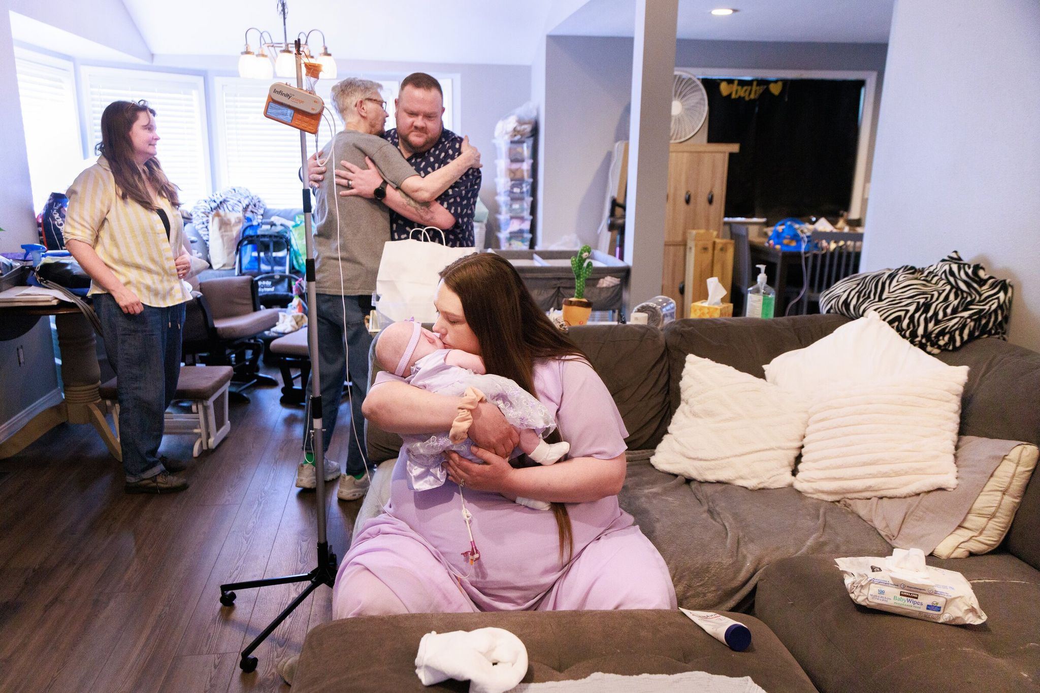 Jessica Adams holds Maxine at home in Pacific for the first time. Husband Kevin Week hugs Jessica’s mother Maxine Lackey, and her older sister Linda Ficken looks on at left. (Erika Schultz / The Seattle Times)