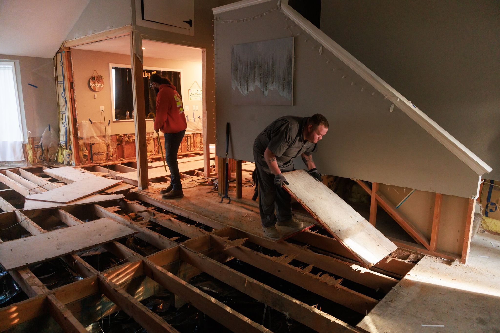 Kevin Week tears out the subfloor to prevent mold and rot. Lacking formal construction training and after talking with expensive contractors, Week began a long rehab with help from friends and family to save money. Despite the extensive work, Week worries about another disaster. 'It’s a matter of when the next flood will happen, not if,' he said. (Erika Schultz / The Seattle Times)