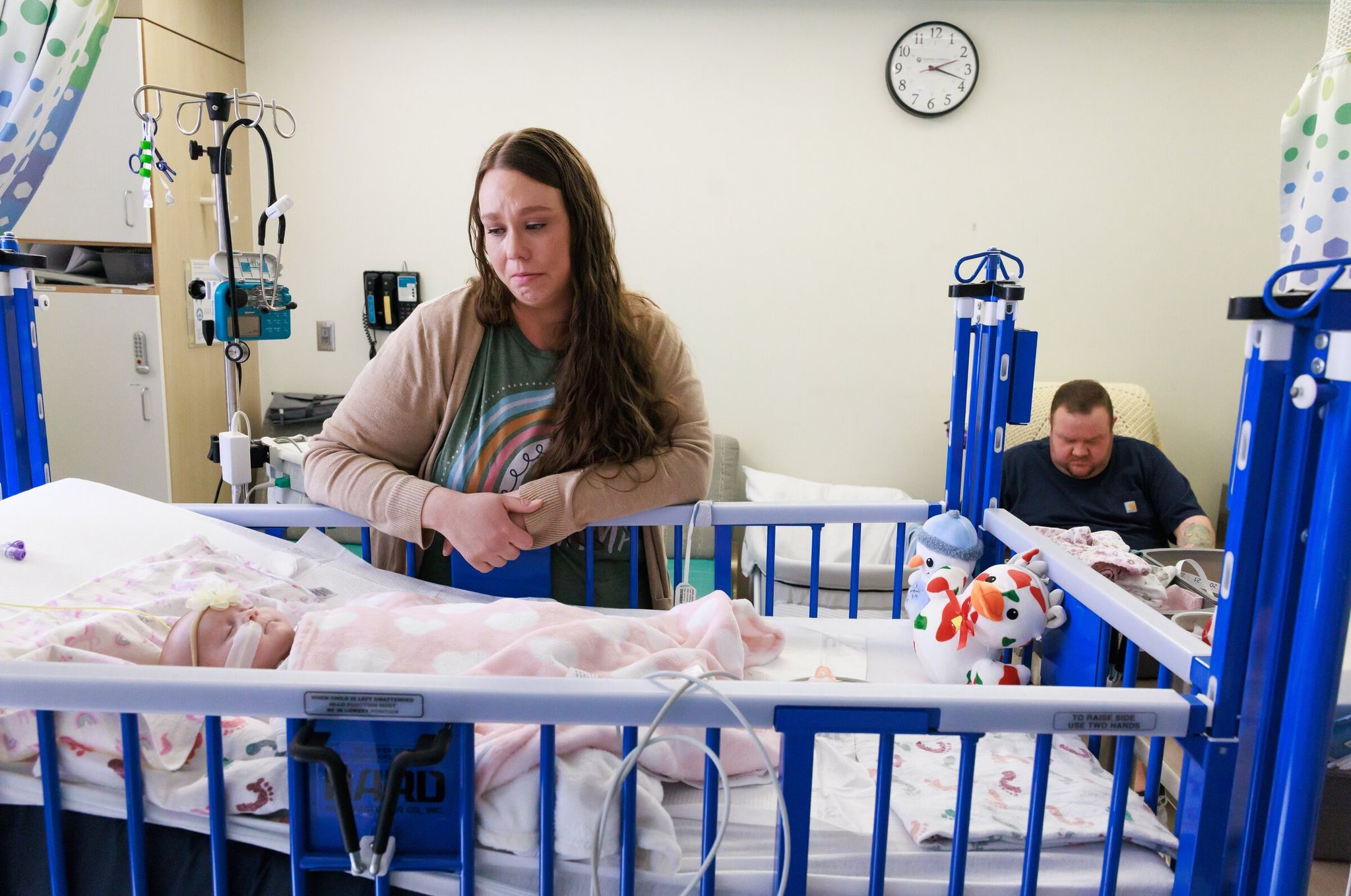 Jessica Adams visits her daughter Maxine at Seattle Children’s while her husband Kevin Week feeds Jackson. The twins, only a few months old at the time, were born prematurely on Halloween, and Maxine underwent several procedures for a rare illness — pulmonary vein stenosis. Jackson was able to leave the neonatal intensive care unit a few weeks after birth. (Erika Schultz / The Seattle Times)