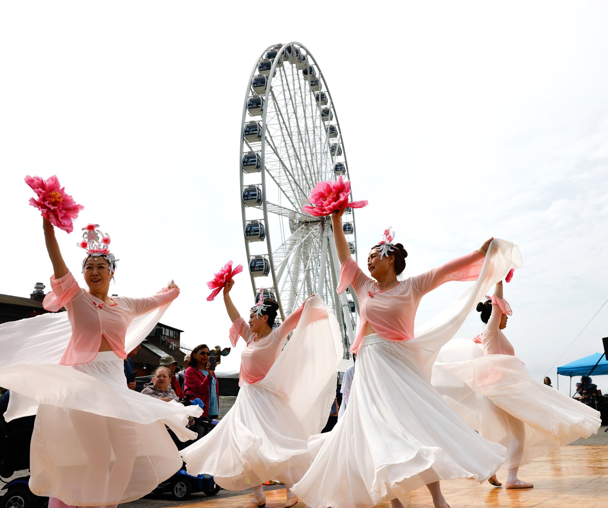 Dancers from the Melody Institute perform “peach blossom,” a dance celebrating the maturation of young girls into adults, at the grand opening of Waterfront Park in Seattle on Sept. 6. (Karen Ducey / The Seattle Times)