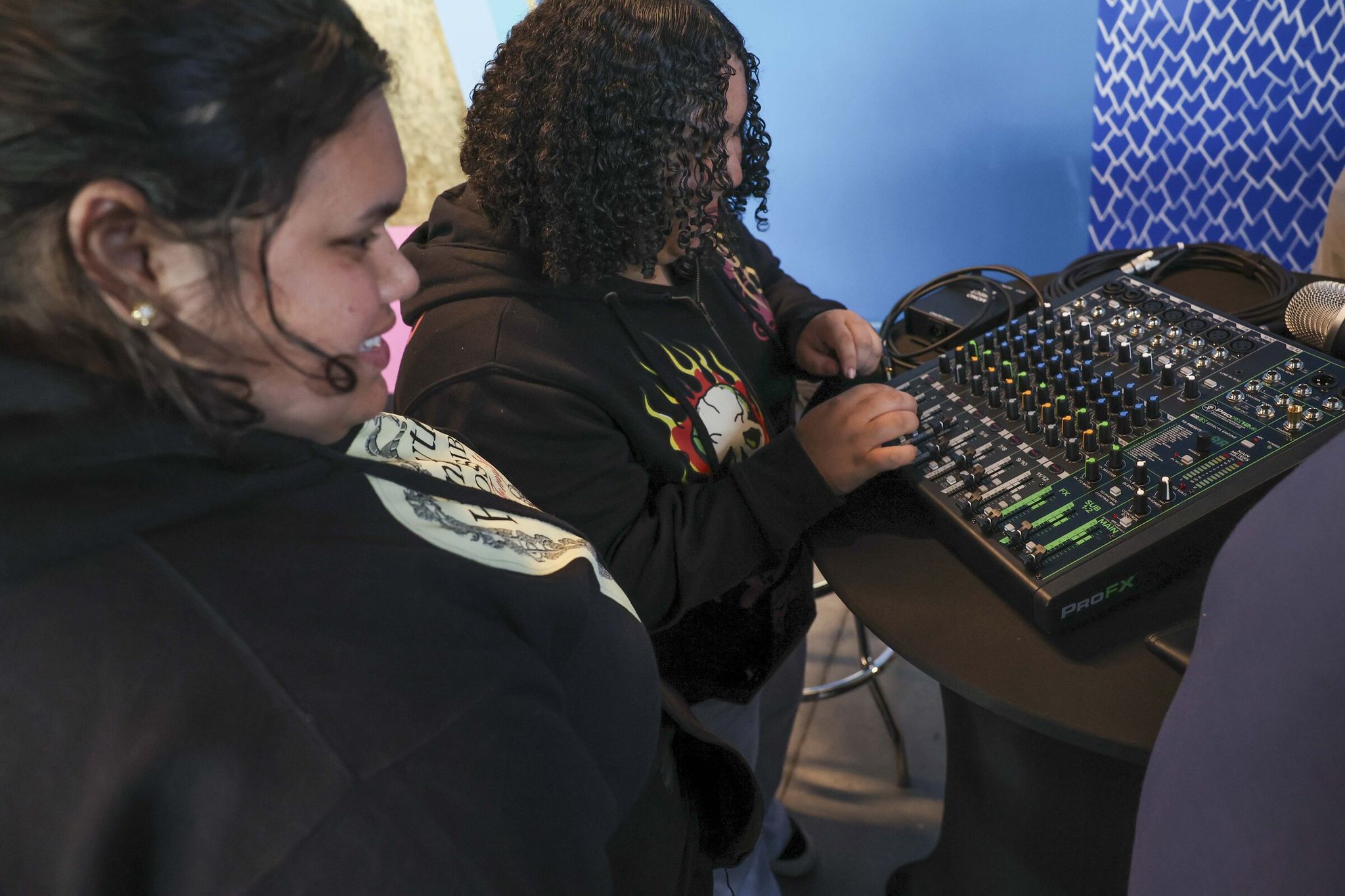 Sisters Louisa Torres Cisneros, 15, left, and Lovea Torres Cisneros, 15, right, explore a soundboard during a production workshop at The Roadhouse under the Angle Lake station in Seatac on April 30. (Ivy Ceballo / The Seattle Times)