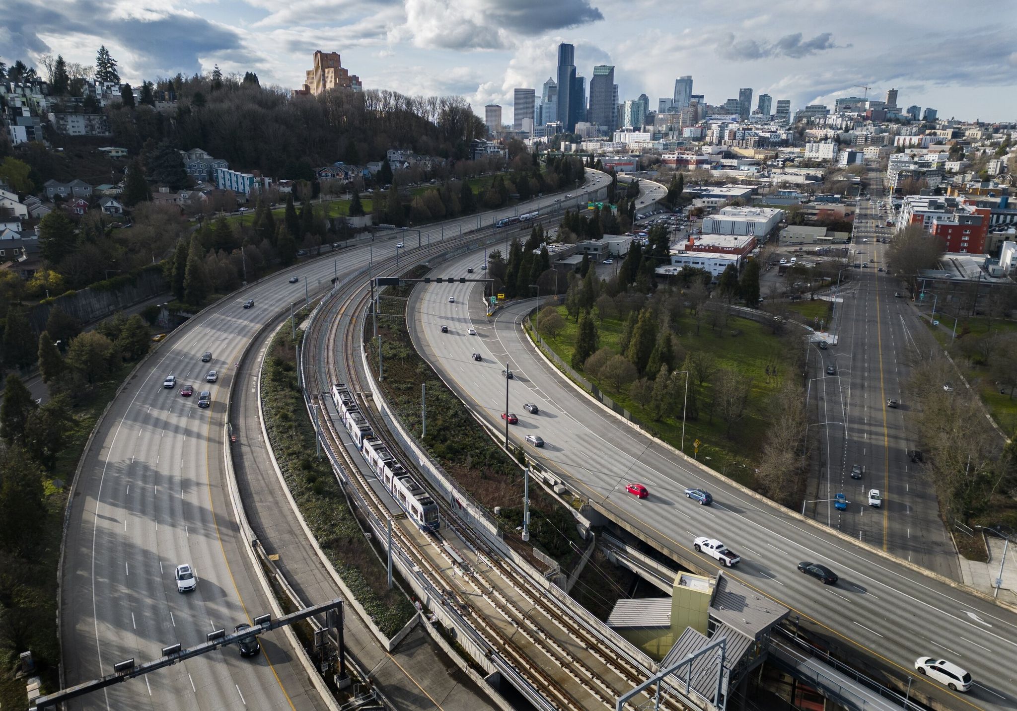 A Sound Transit link light rail train near the Judkins Park station (at lower right), Thursday, March 12, 2026. The Link 2 Line, which connects Lynnwood to Redmond, opened March 28. The Seattle skyline is at top right, and I-90 is on either side of the station. (Ellen M. Banner / The Seattle Times)
