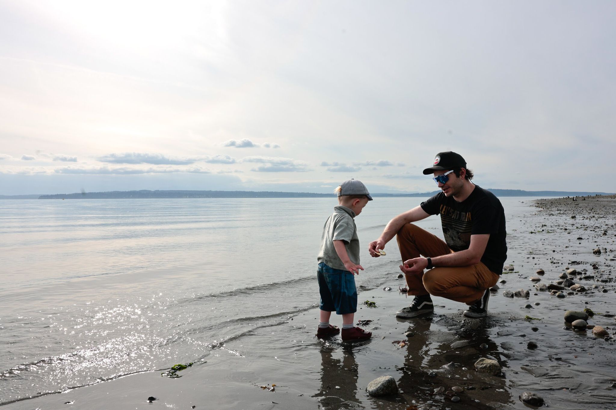 Peter Erglis and his son, Daniel Erglis, 2, from the Greenwood neighborhood enjoy a stroll on the beach at Richmond Beach Saltwater Park in Shoreline. They enjoy this park, saying it’s less crowded than the beaches in Seattle. (Karen Ducey / The Seattle Times)