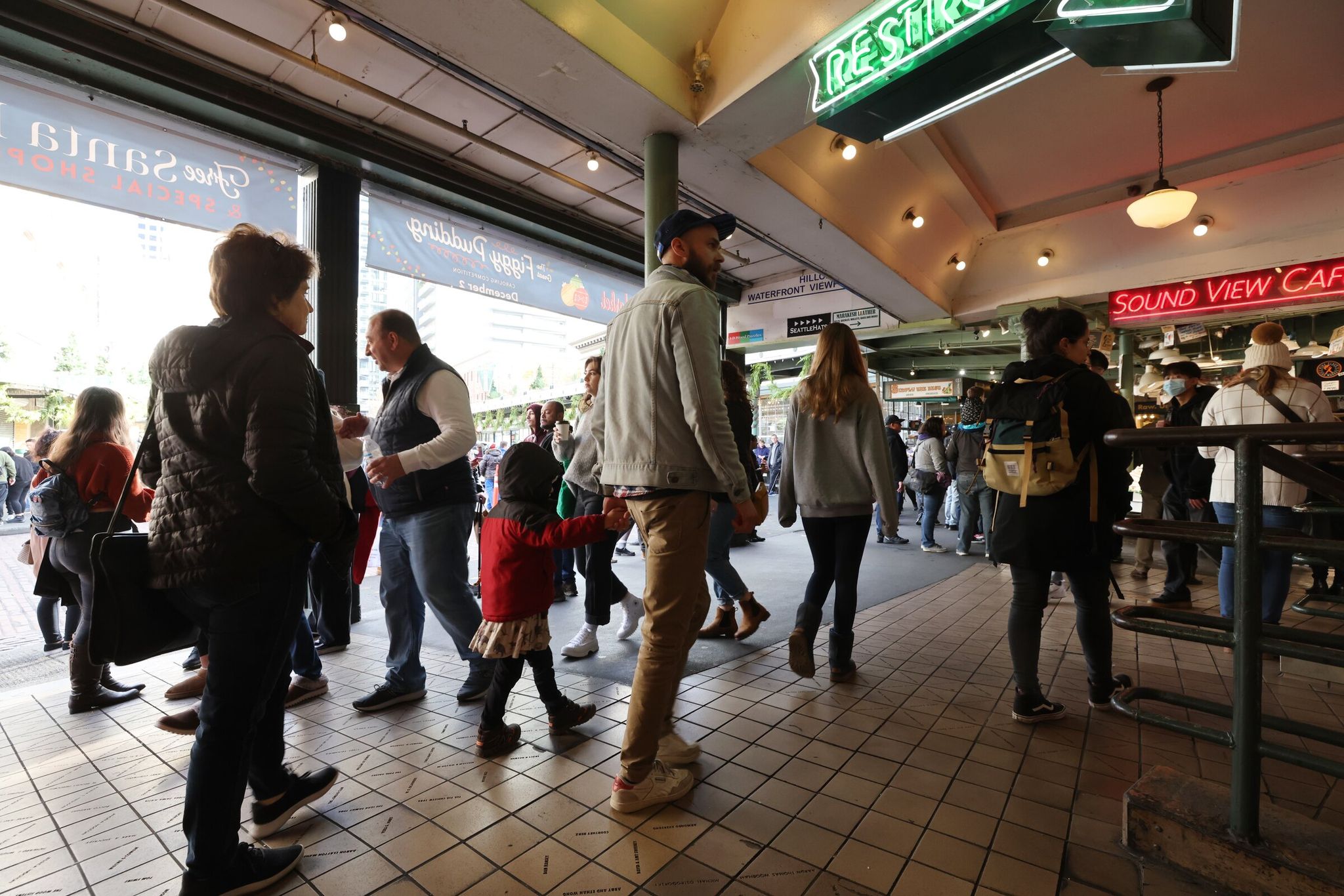 Shoppers walk in the upper street level of Pike Place Market. (Karen Ducey / The Seattle Times, 2022)
