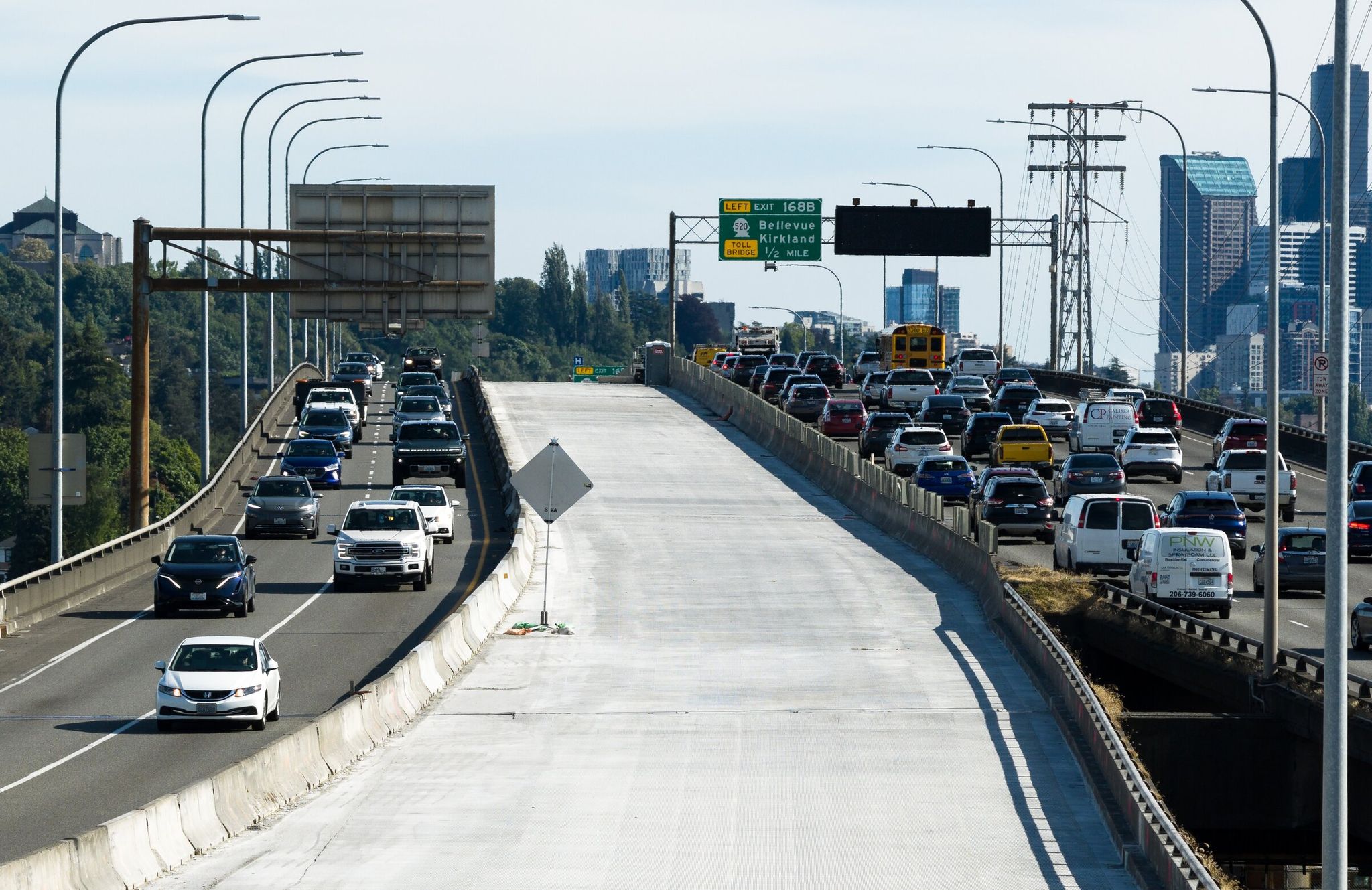 Two northbound lanes of fresh concrete, which still need smoothing, grooving and striping, are on schedule to reopen June 8, boosting capacity on the I-5 Ship Canal Bridge during the “summer of soccer.” Then in mid-July, the two right lanes will close for a half-year repave. (Nick Wagner / The Seattle Times)
