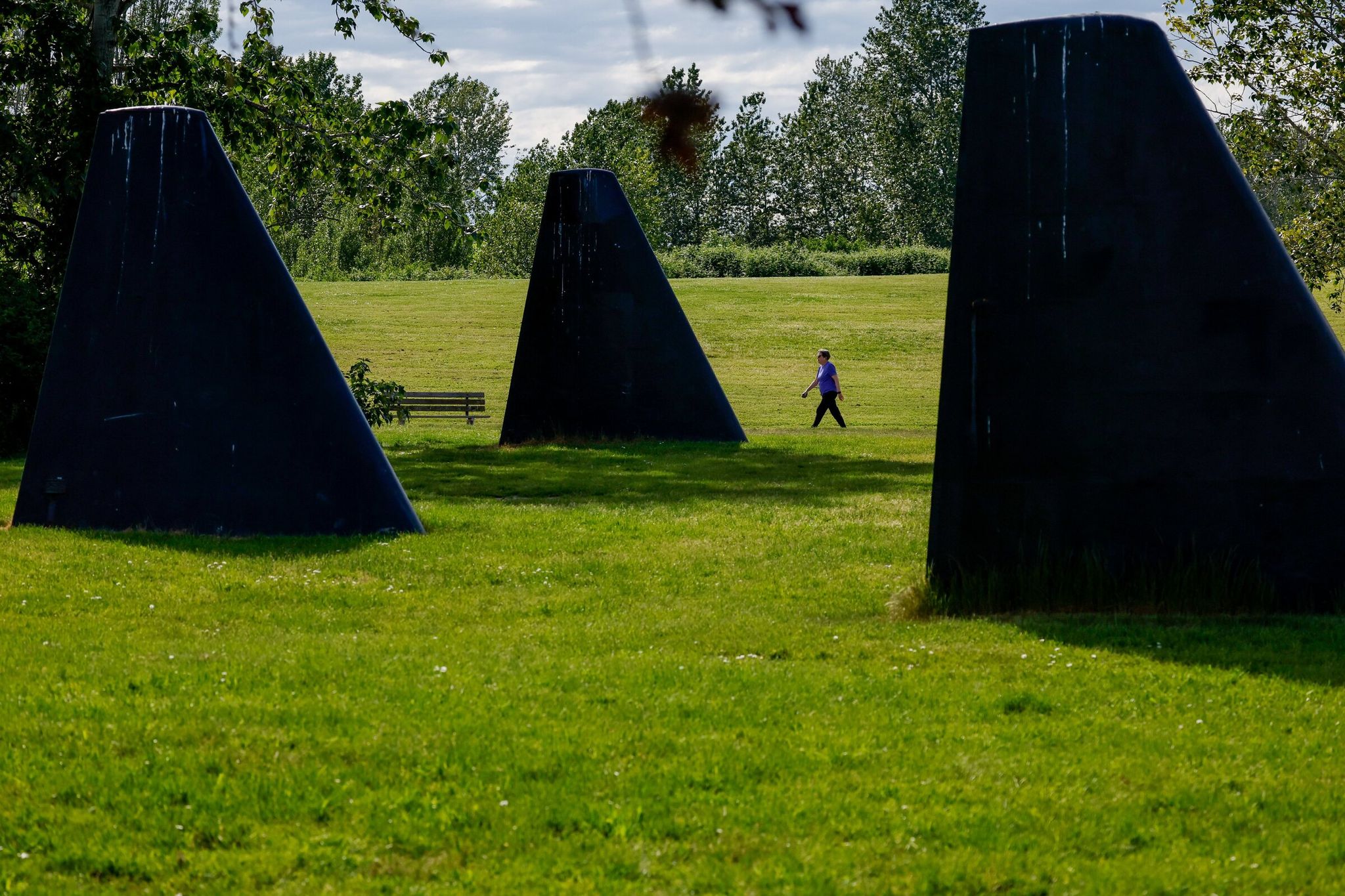 A person walks along a path at Magnuson Park near the public art installation “The Fin Project: From Swords Into Plowshares” by John T. Young. Ninety-nine percent of Seattleites are within a 10-minute walk of a park. (Jennifer Buchanan / The Seattle Times)