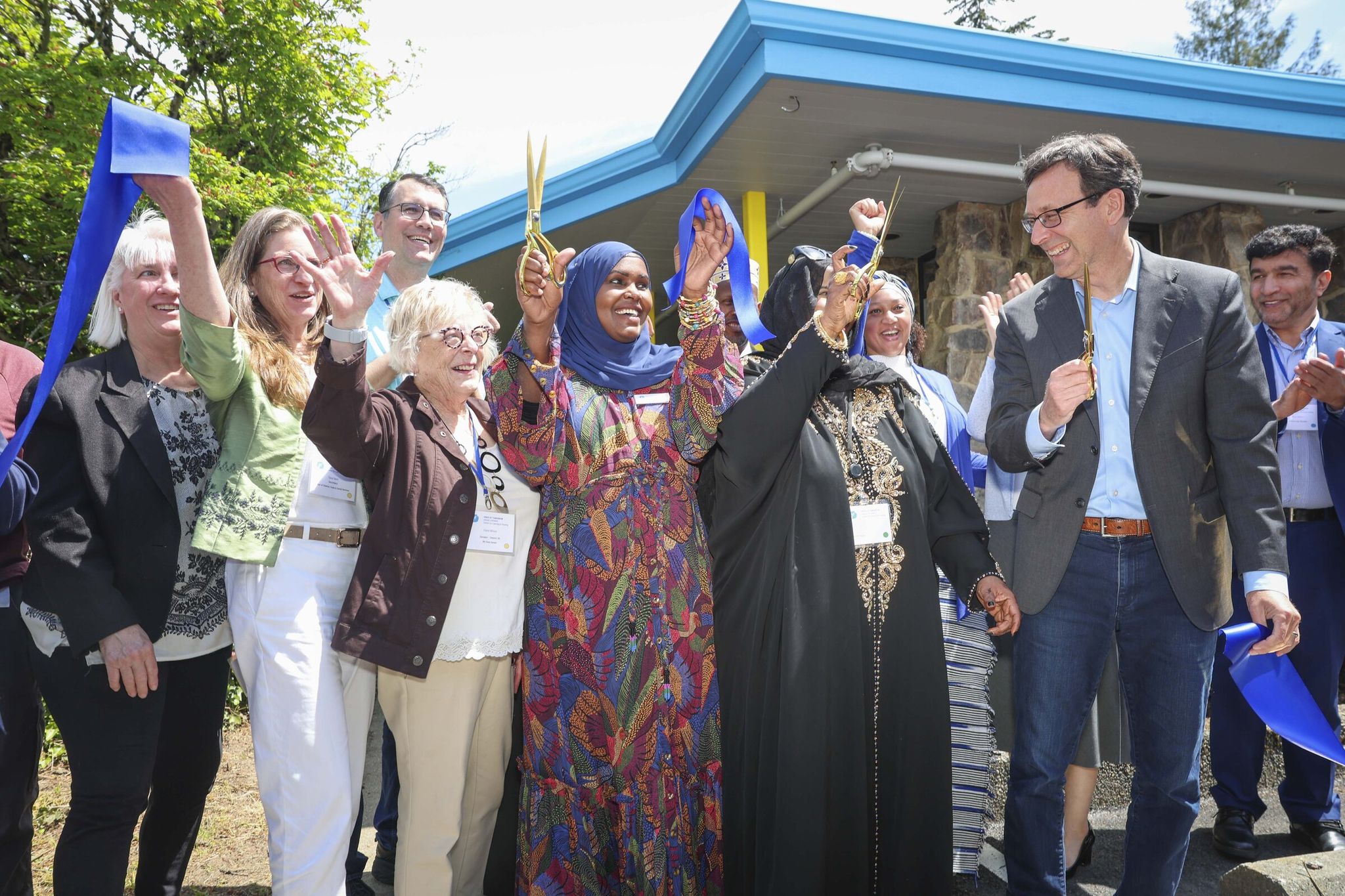 Front row, left to right: Kate Kruller, Tukwila City Council member; Tana Senn, secretary of the Department of Children, Youth and Families; state Sen. Claire Wilson, a Democrat from Auburn; Zamzam Mohamed, CEO of Voices of Tomorrow; Falis Ali; and Gov. Bob Ferguson celebrate the ribbon-cutting during the grand opening of the Voices of Tomorrow Center for Learning and Healing in Tukwila on Thursday, May 21. (Ivy Ceballo / The Seattle Times)