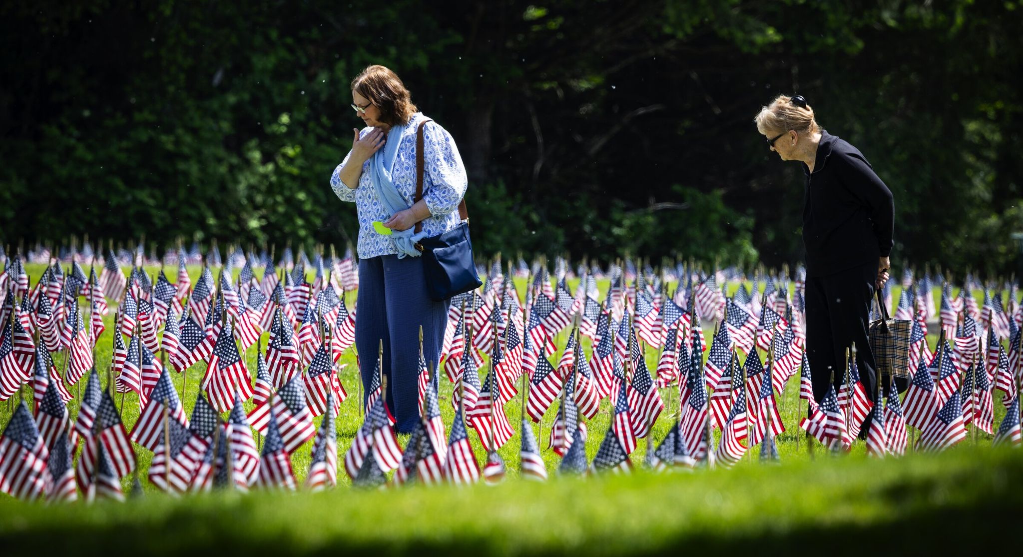 Tina Matz, left, and her mother Joanne Matz visit the grave of Tina’s grandfather, Vernon Easterlin Sr., a survivor of the Battle of the Bulge, after flags were set out Thursday in advance of Memorial Day to honor veterans who have passed, at Tahoma National Cemetery in Kent. (Ken Lambert / The Seattle Times)