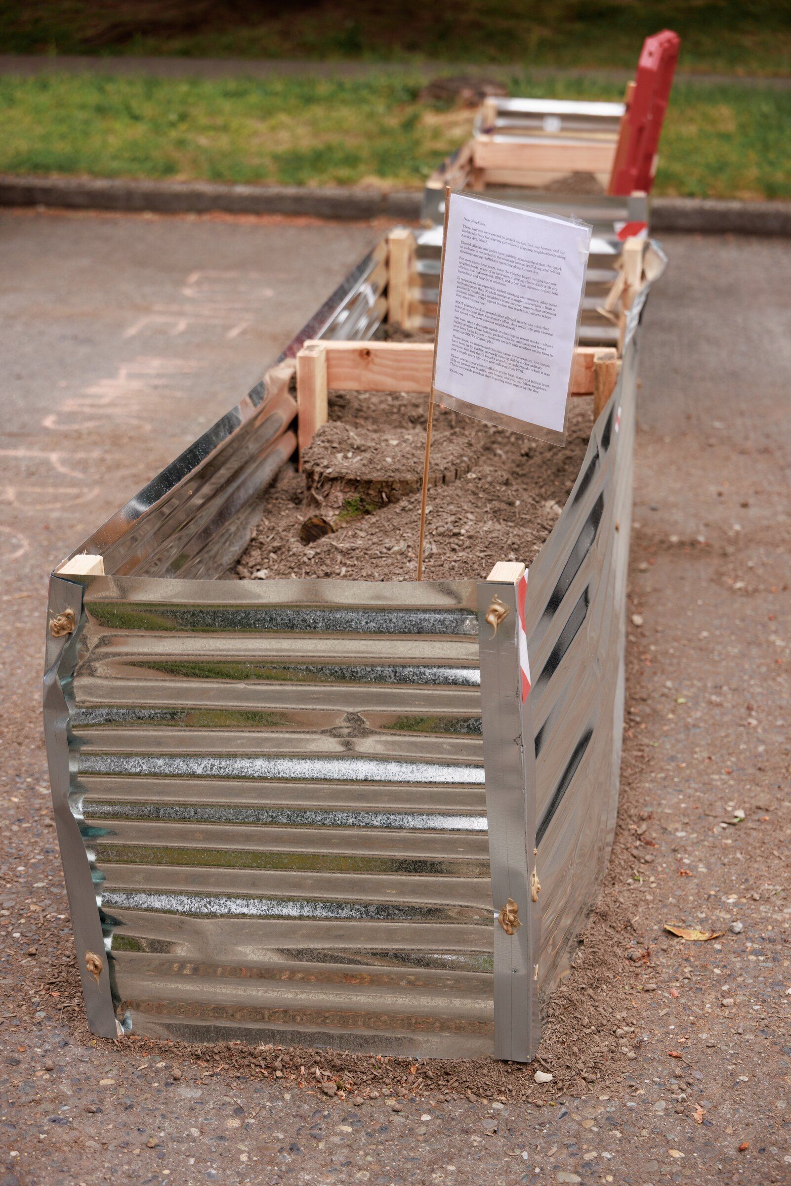Residents blocked three side streets west of Aurora Avenue North with steel planters filled with soil in response to shootings in the area this month. The message partly reads: 'These barriers are installed to protect our families, our homes and livelihoods from the ongoing armed violence engulfing areas along Aurora Ave. North.' (Erika Schultz / The Seattle Times)