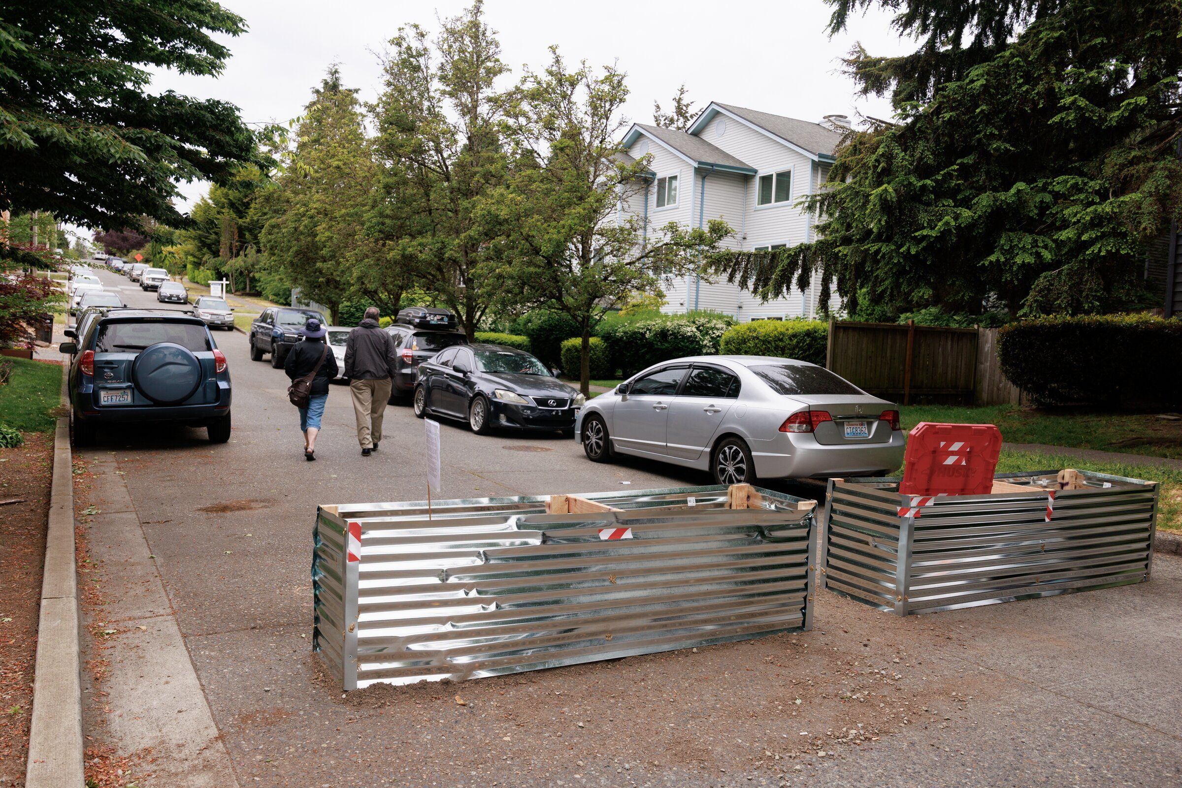 Pedestrians walk past barriers set up near Linden Avenue North and North 98th Street. (Erika Schultz / The Seattle Times)