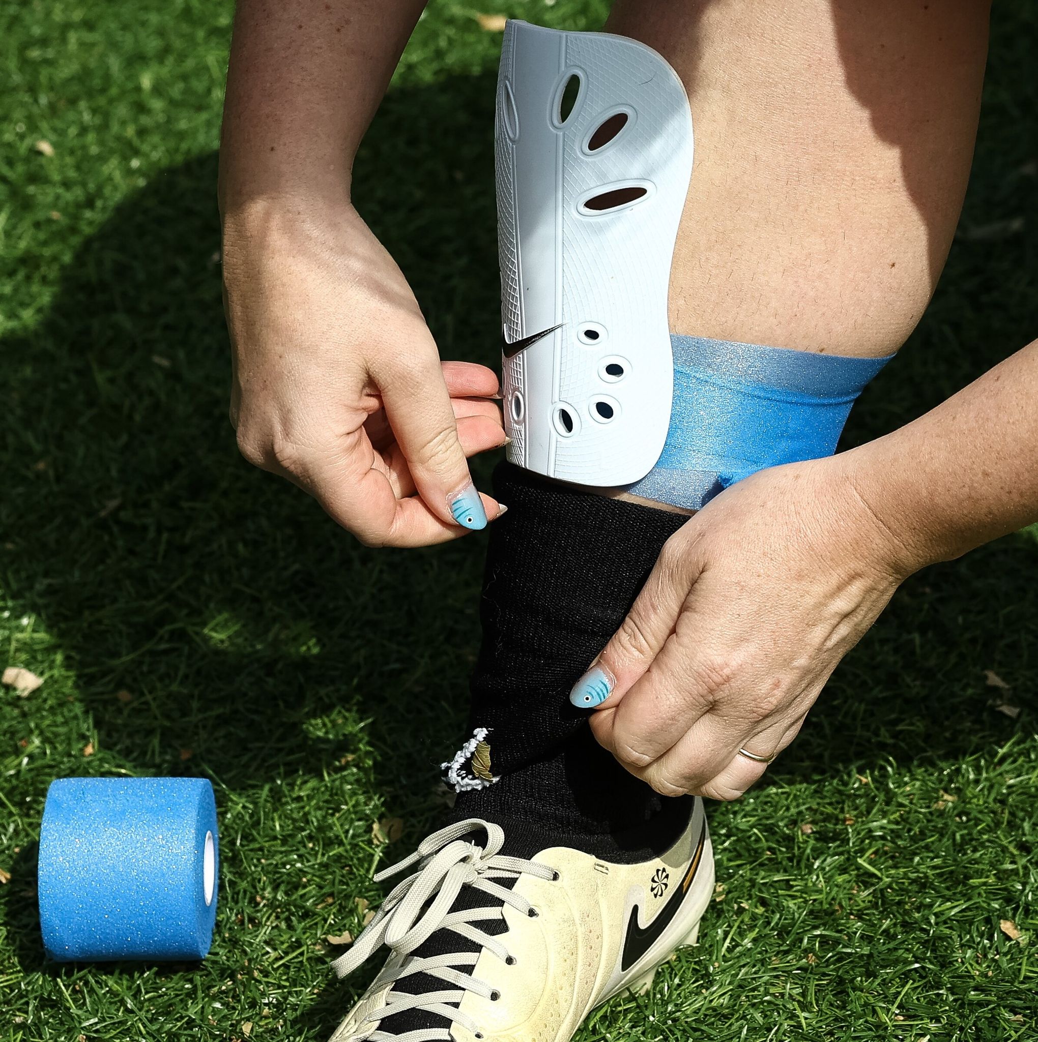 Sarah Montgomery secures her shin guards before a soccer match. (Nick Wagner / The Seattle Times)