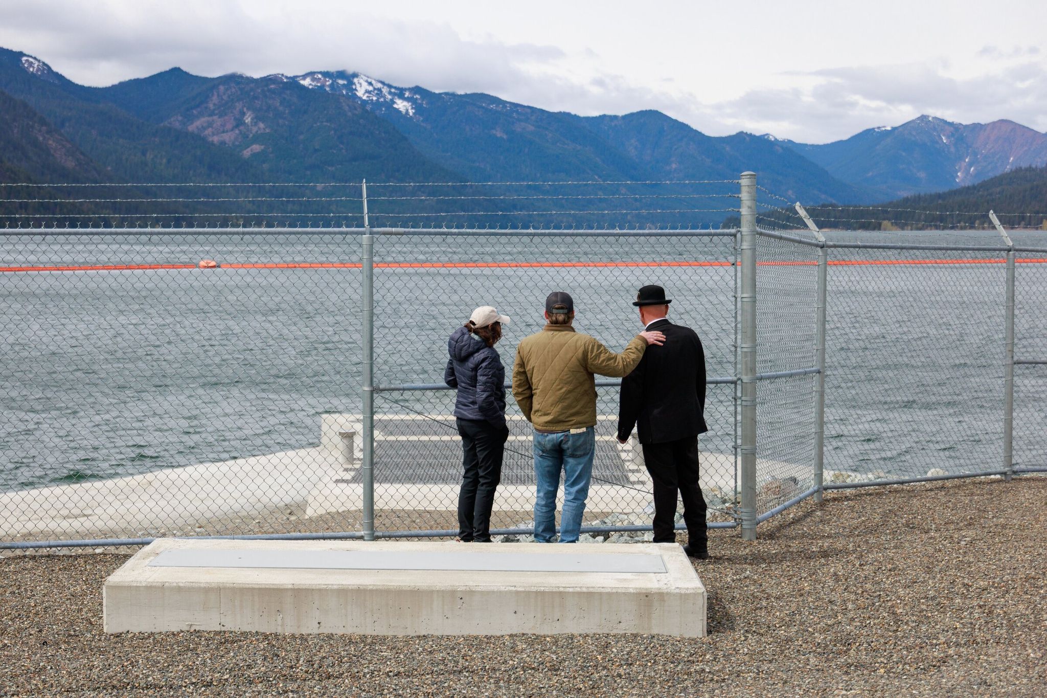 Left to right: Susan Woodward, communications director for the Northwest at American Rivers; Brandon Parsons, director of river restoration at American Rivers; and Urban Eberhart, secretary-manager of the Kittitas Reclamation District, speak during a tour of the fish passage facilities at Cle Elum Lake. In the distance are Cle Elum Reservoir and the Cascade Mountains. (Erika Schultz / The Seattle Times)