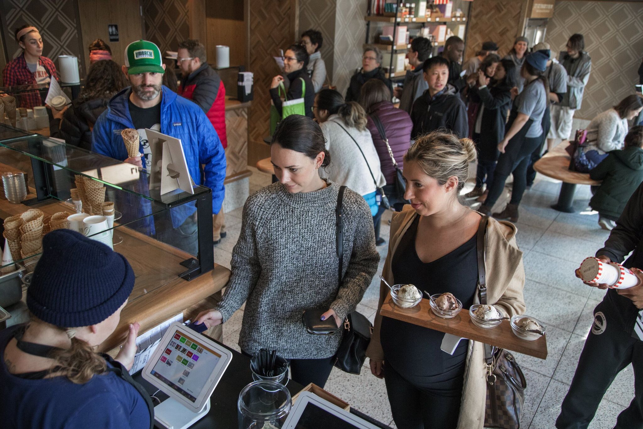 Salt and Straw in Ballard, Lyndsay Ediger works the cash as the line builds for scoops of ice cream. (Steve Ringman / The Seattle Times, 2018)
