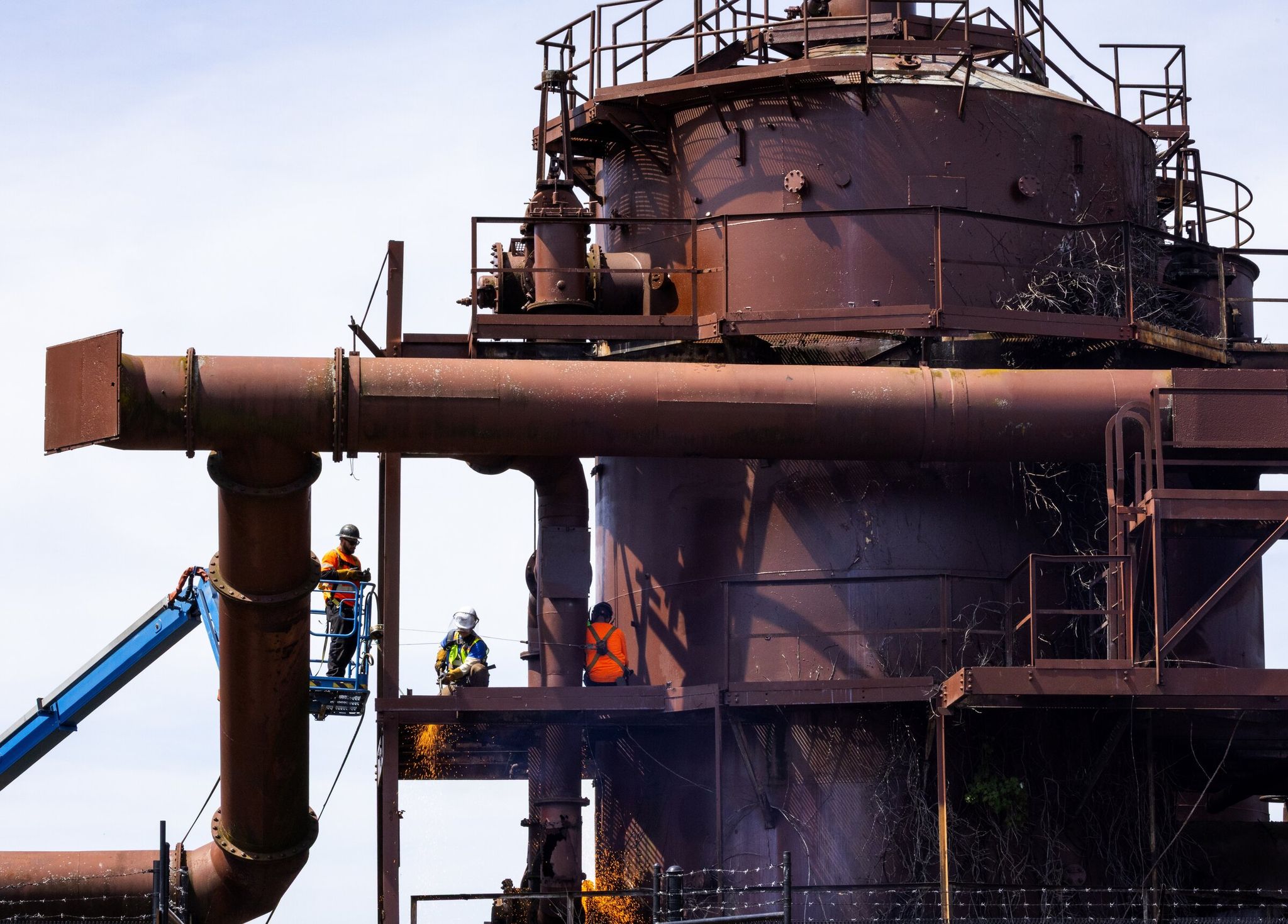 Using cutting torches, crews work at removing catwalks, railings and other structures deemed dangerous at Gas Works Park on May 4 in Seattle. (Ken Lambert / The Seattle Times)