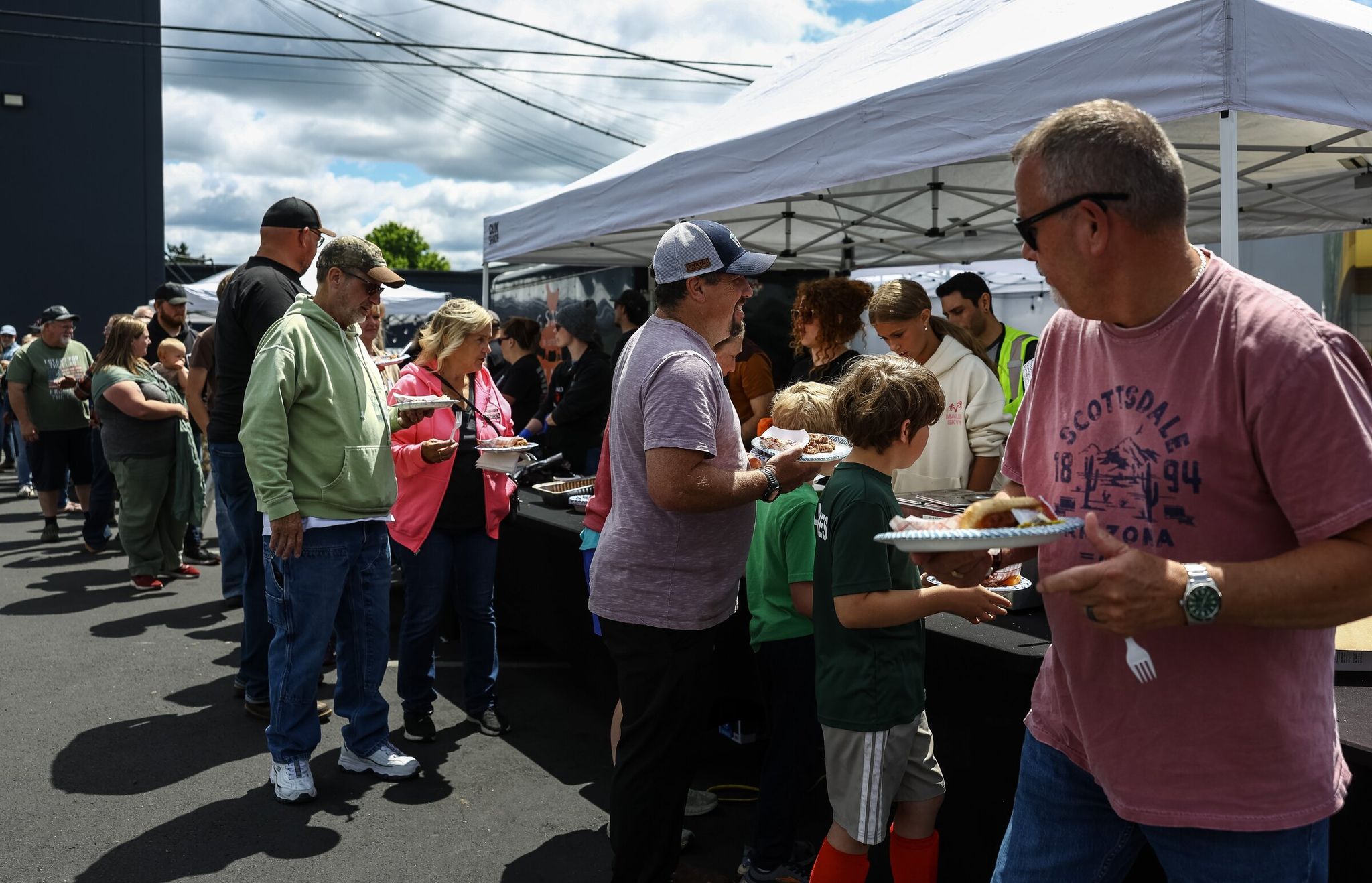 People line up to donate money and get food during a community barbecue and Nippon Family Fundraiser on Saturday in Longview. Although the main goal Saturday was raising money to help workers and their families pay rent and provide children with food and clothing, the day was also about bringing the community together. (Nick Wagner / The Seattle Times)