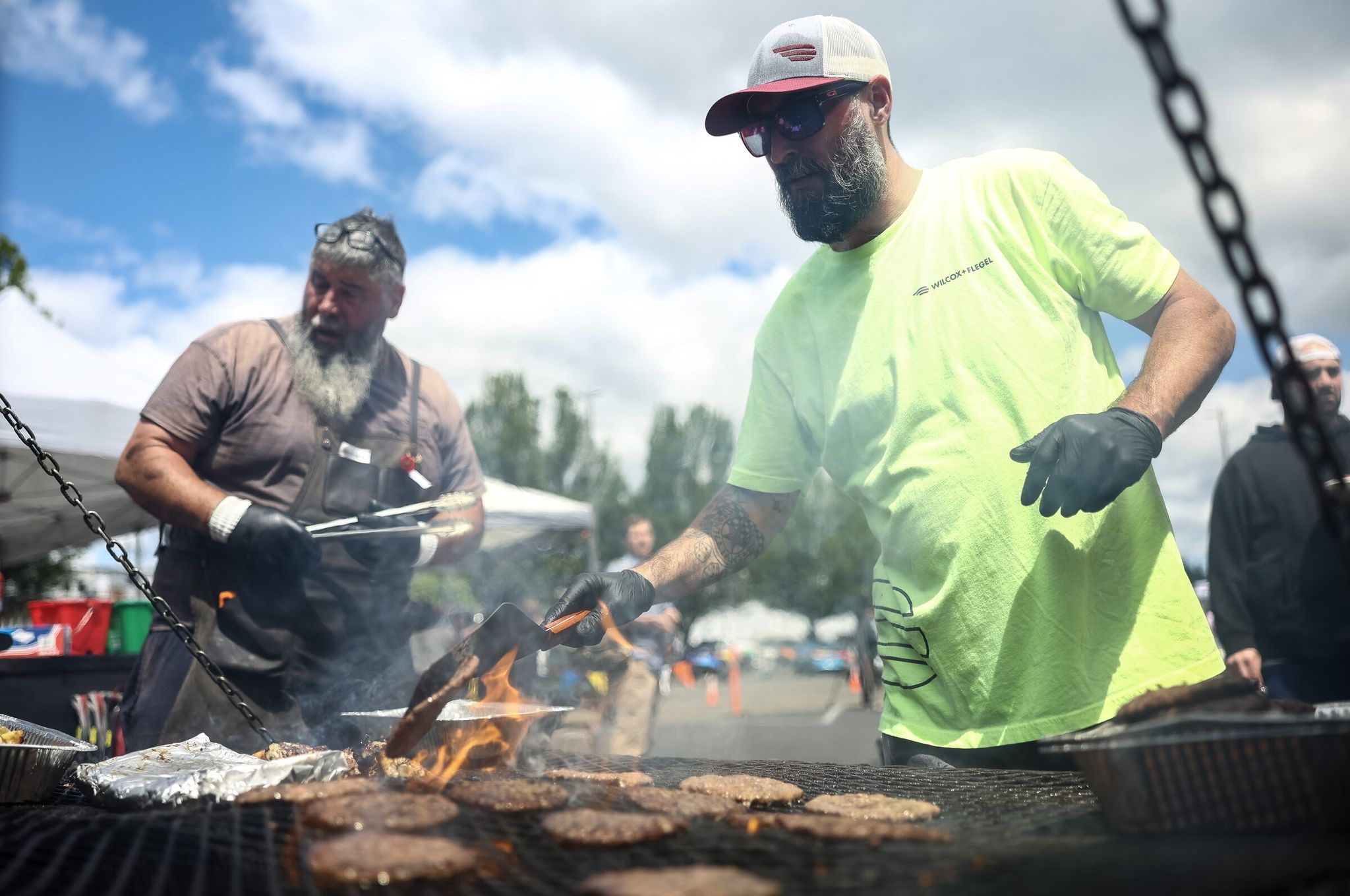 Ryan Stotts grills burgers during the community barbecue and fundraiser on Saturday in Longview. (Nick Wagner / The Seattle Times)