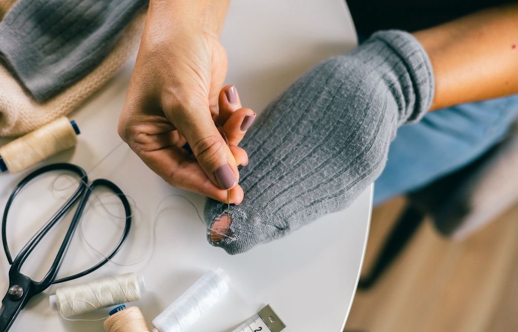 These students mend clothes together instead of tossing them out