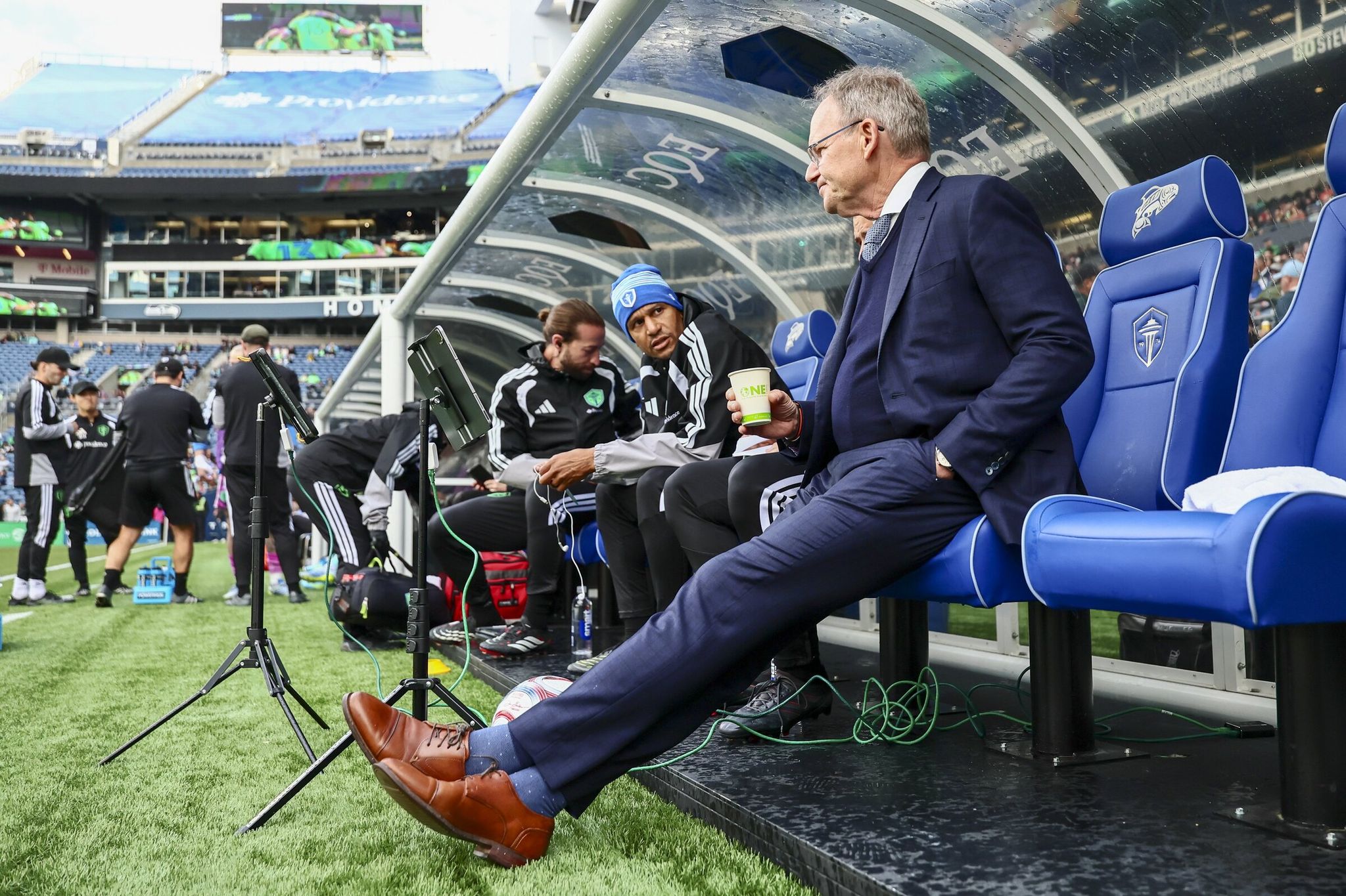 Brian Schmetzer sits on the sideline bench before kickoff against the San Jose Earthquakes at Lumen Field in Seattle on May 13, 2026. Seattle won 3-2. (Kevin Clark / The Seattle Times)
