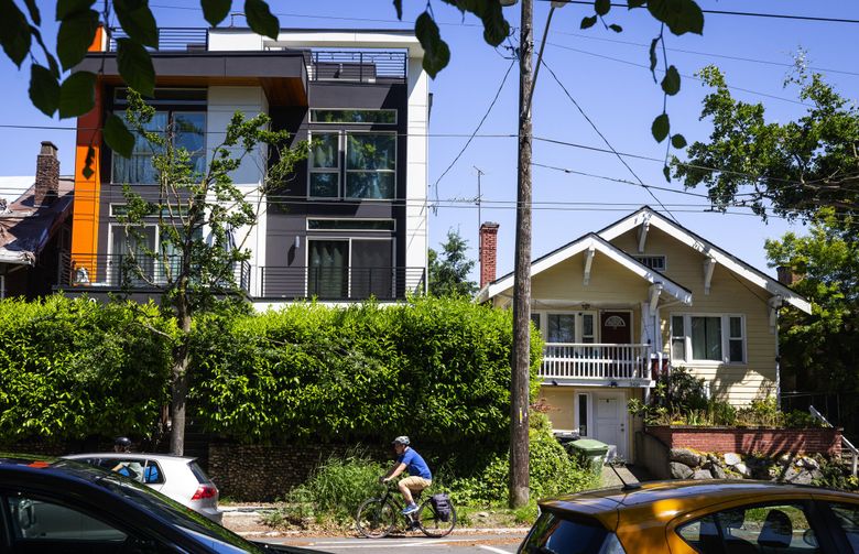 A newer and older home, side-by-side, are seen in May in Seattle’s Beacon Hill neighborhood. New protected bike lanes are on either side of the neighborhood’s main drag. (Ken Lambert / The Seattle Times)