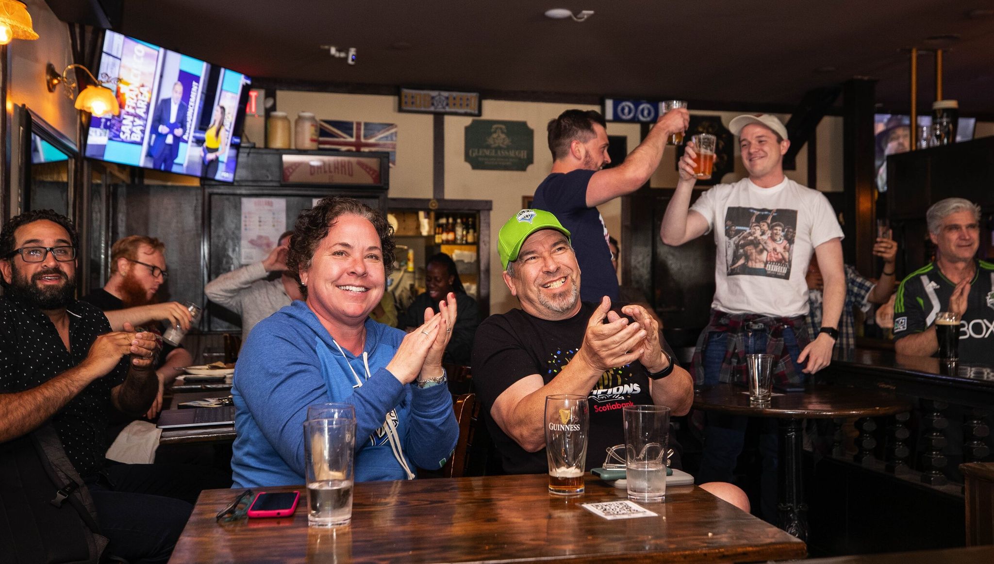 Soccer fans celebrate the 2022 announcement of World Cup games in Seattle at the George and Dragon. (Dean Rutz / The Seattle Times)